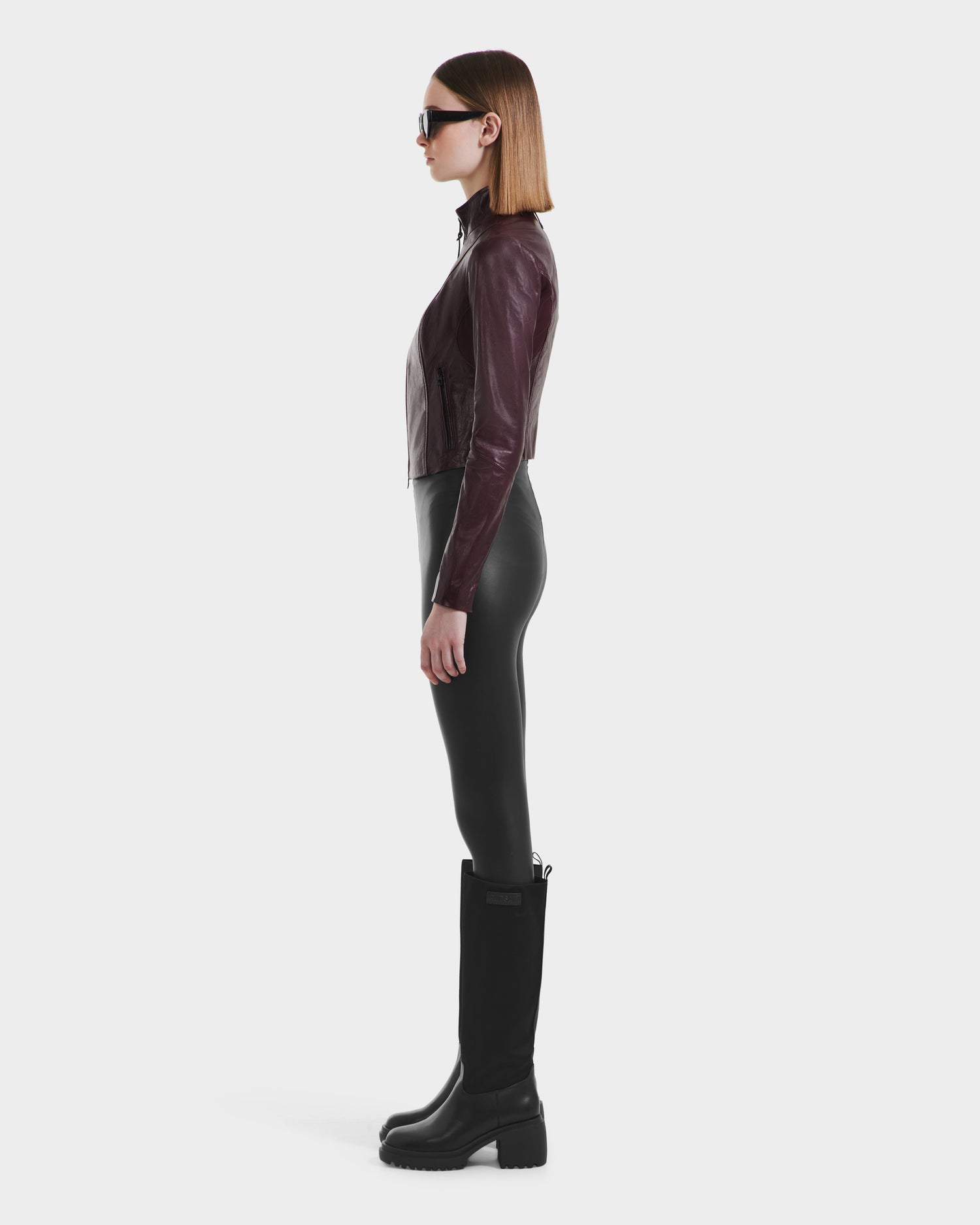 A woman in a Rudsak ABIGAIL - 8124560 Bordeaux jacket and boots.