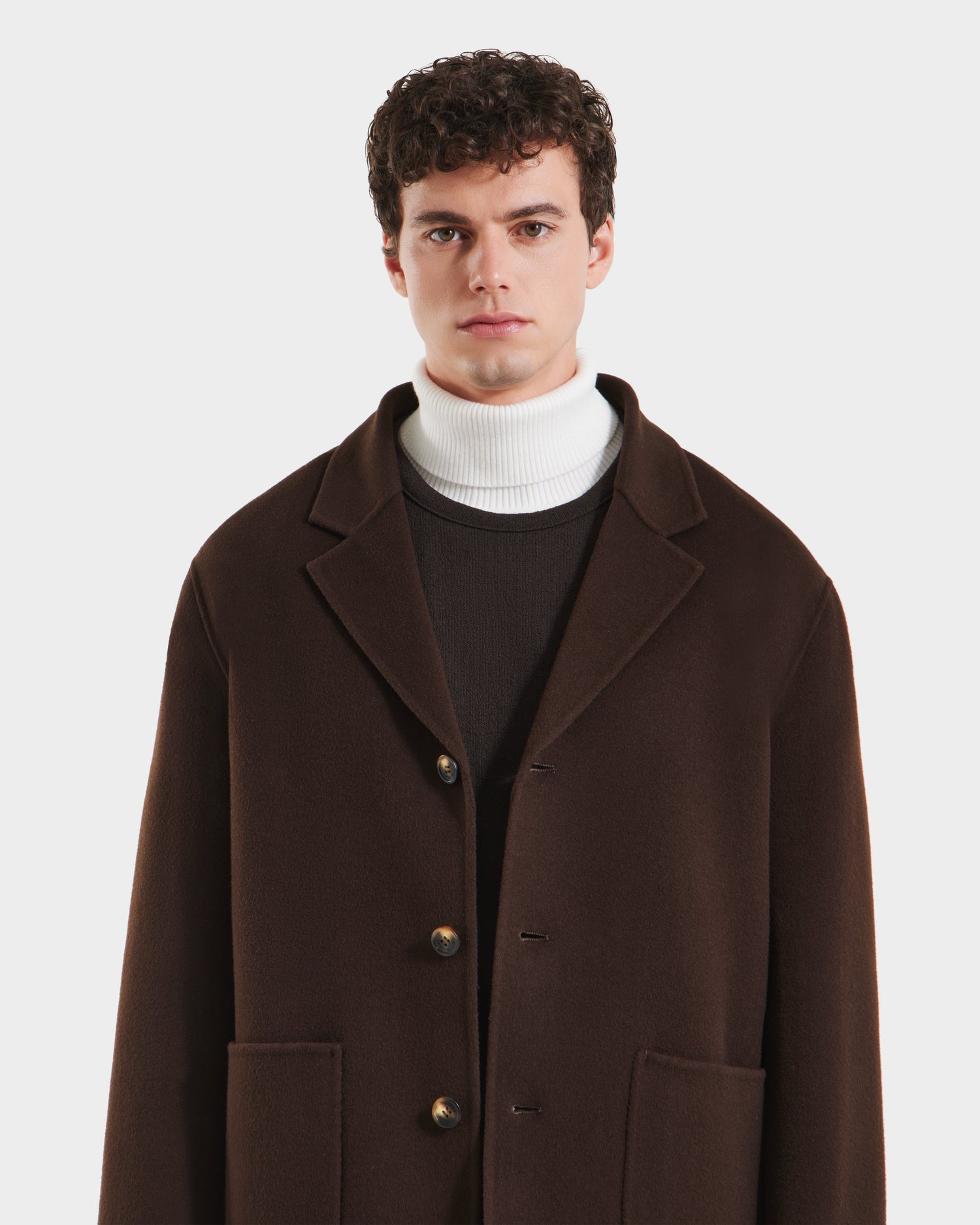 A man in the Rudsak AIDEN - 6125558 Espresso, a refined men’s wool-blend coat featuring a removable shearling collar.