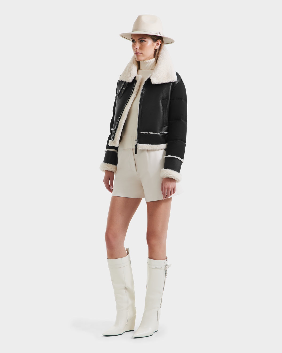 A woman in a hat and the Rudsak ANA - 8125508 Black, a stylish women’s shearling jacket with leather trim.
