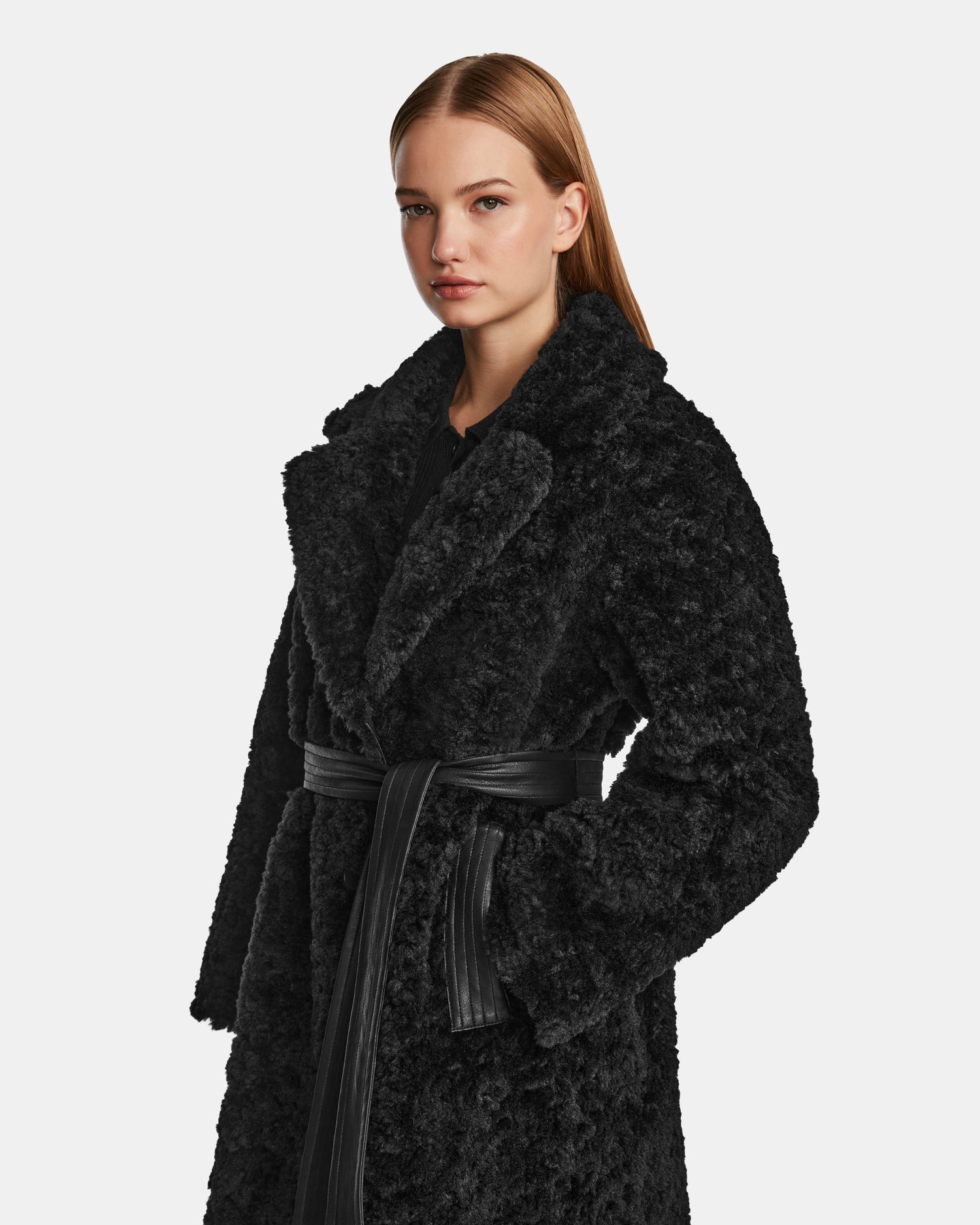 A woman in the chic Rudsak ANNABELLE - L124544 Black vegan leather coat.