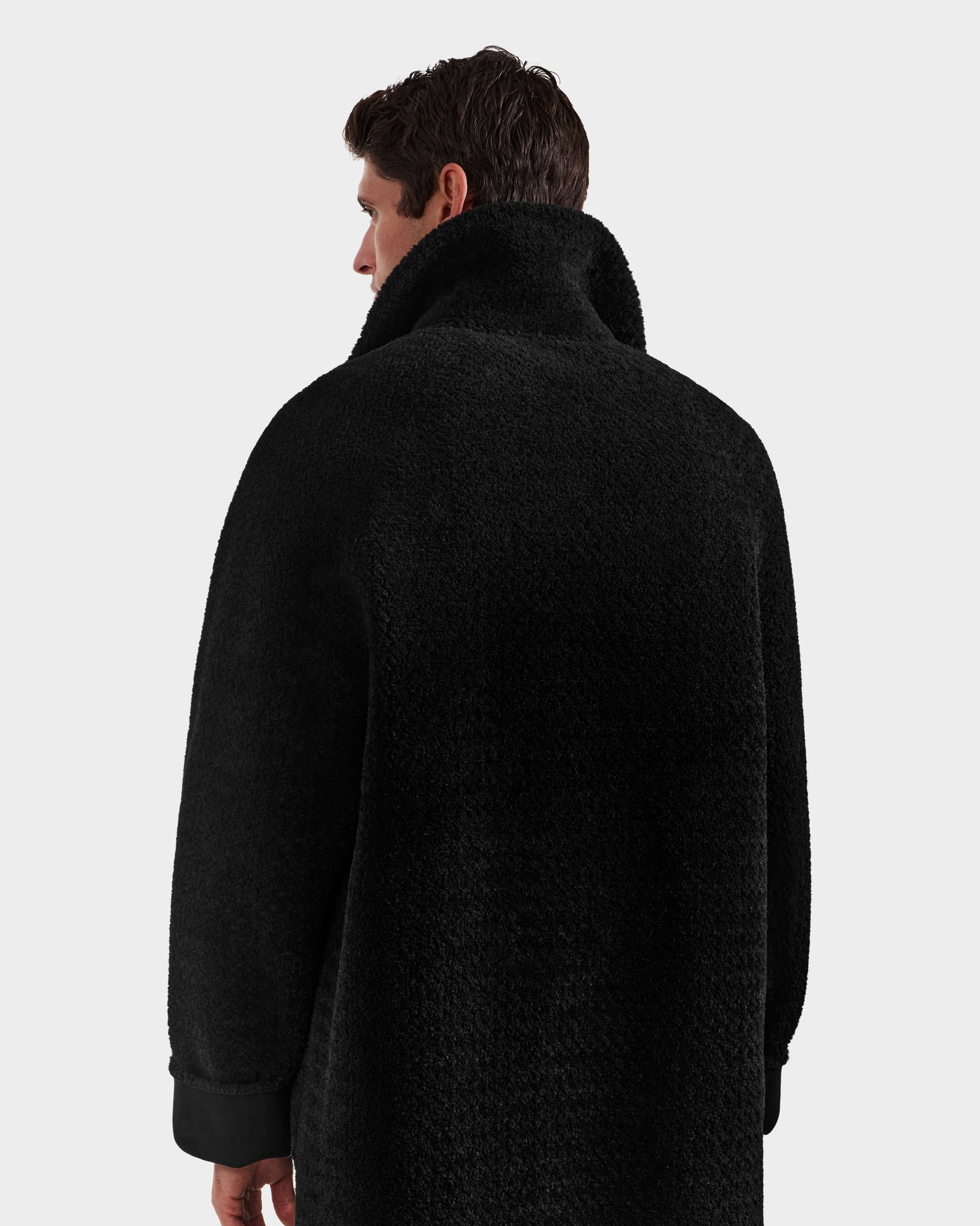 A man with short dark hair is seen from behind, wearing the Rudsak BENITO - M125533 Black reversible men’s overcoat with a high collar, set against a plain light background.