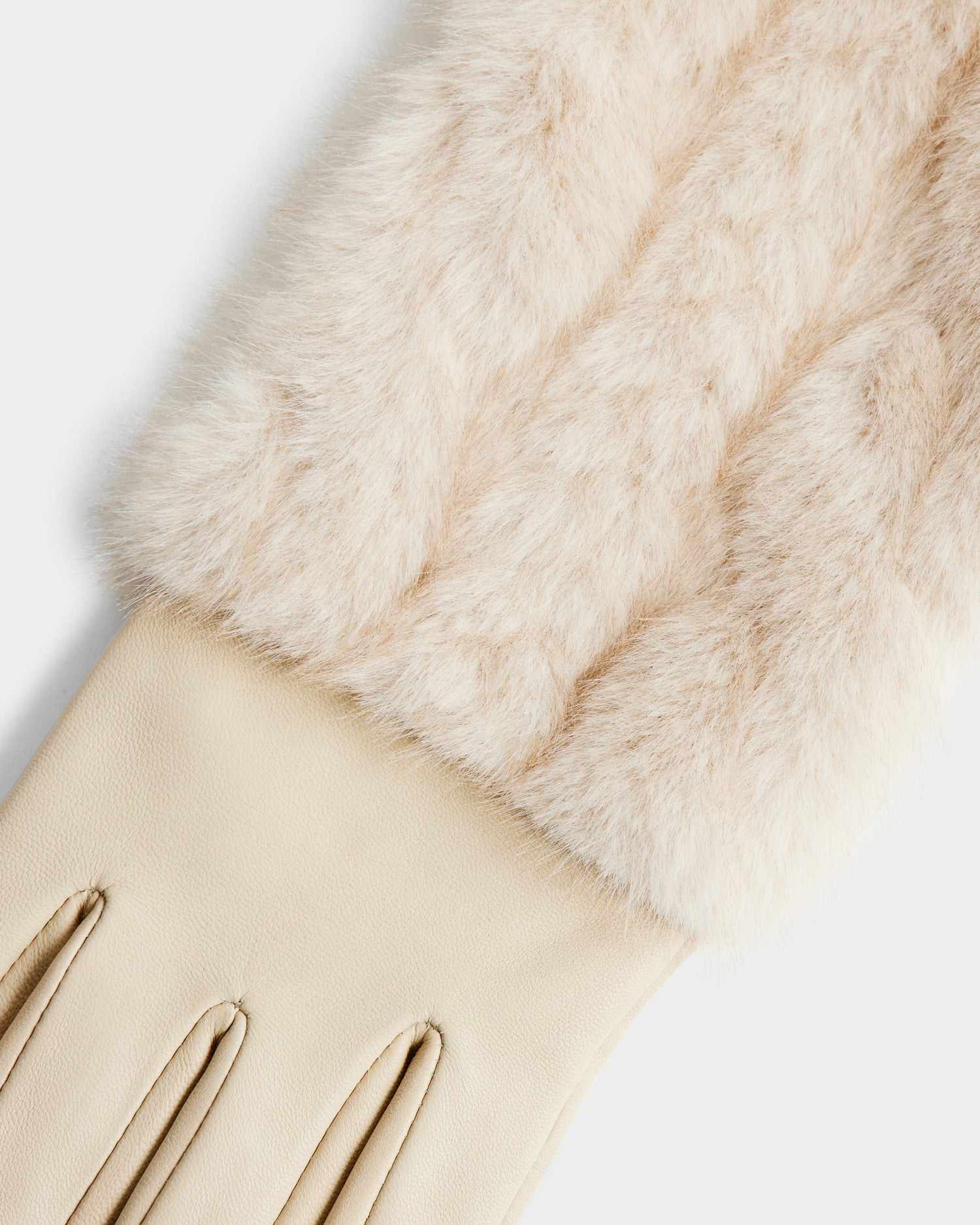 A close-up of the Rudsak COVE - 8425533 Vanilla gloves, featuring beige faux fur with a soft, fluffy cuff, smooth leather hand portion, and stitched detailing on top.