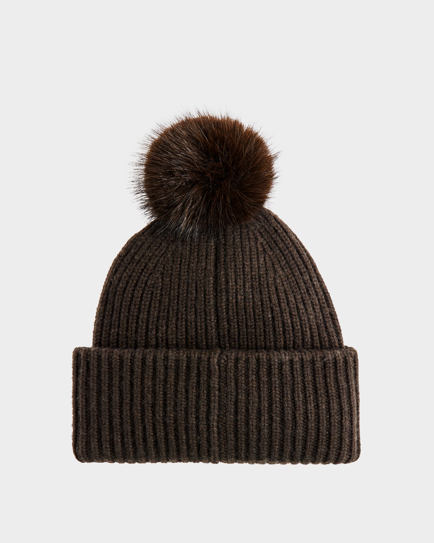 The Rudsak DARA - 8425019 Dark Olive is a women’s ribbed knit tuque in dark olive with a folded brim and large faux fur pom pom, crafted from a soft cashmere wool blend, shown against a plain light gray background.