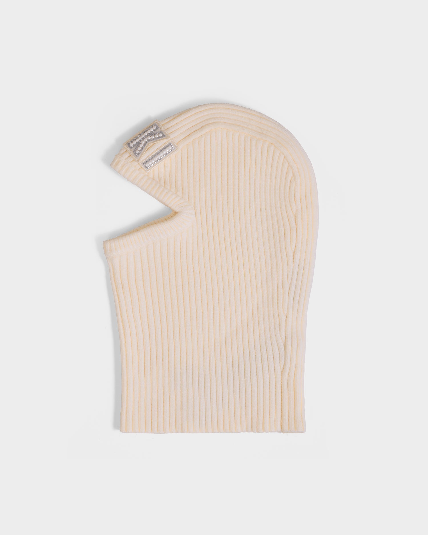 The Rudsak DIXIE - 8425551 Vanilla is a ribbed, cream knit women's balaclava with single eye and mouth openings, plus a silver-detailed rectangular label near the top—ideal for your winter wardrobe.
