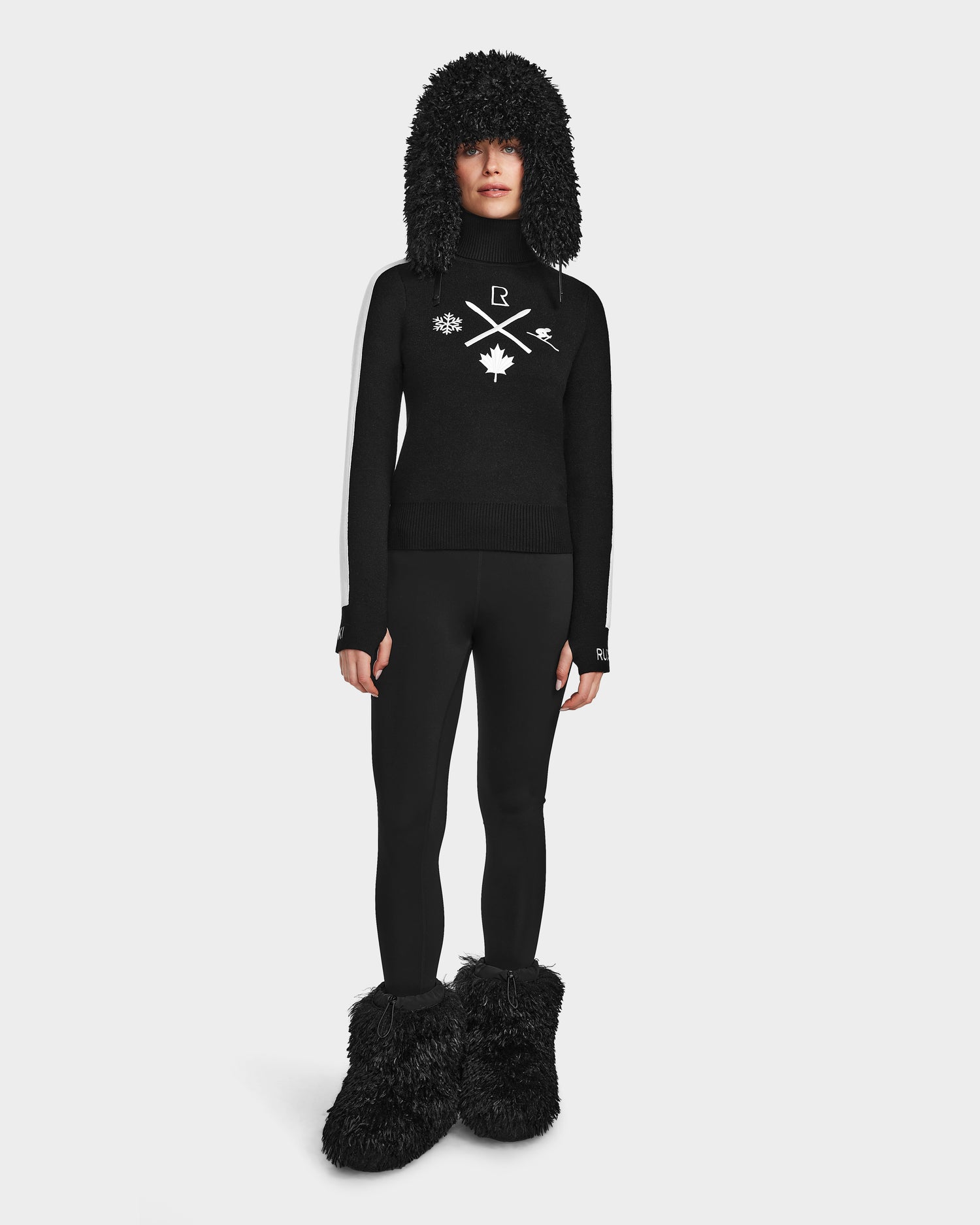A woman wears the Rudsak ELIZABETH - 8524623 Black sweater and pants set—ideal for a chic winter wardrobe or as a cozy après-ski turtleneck.
