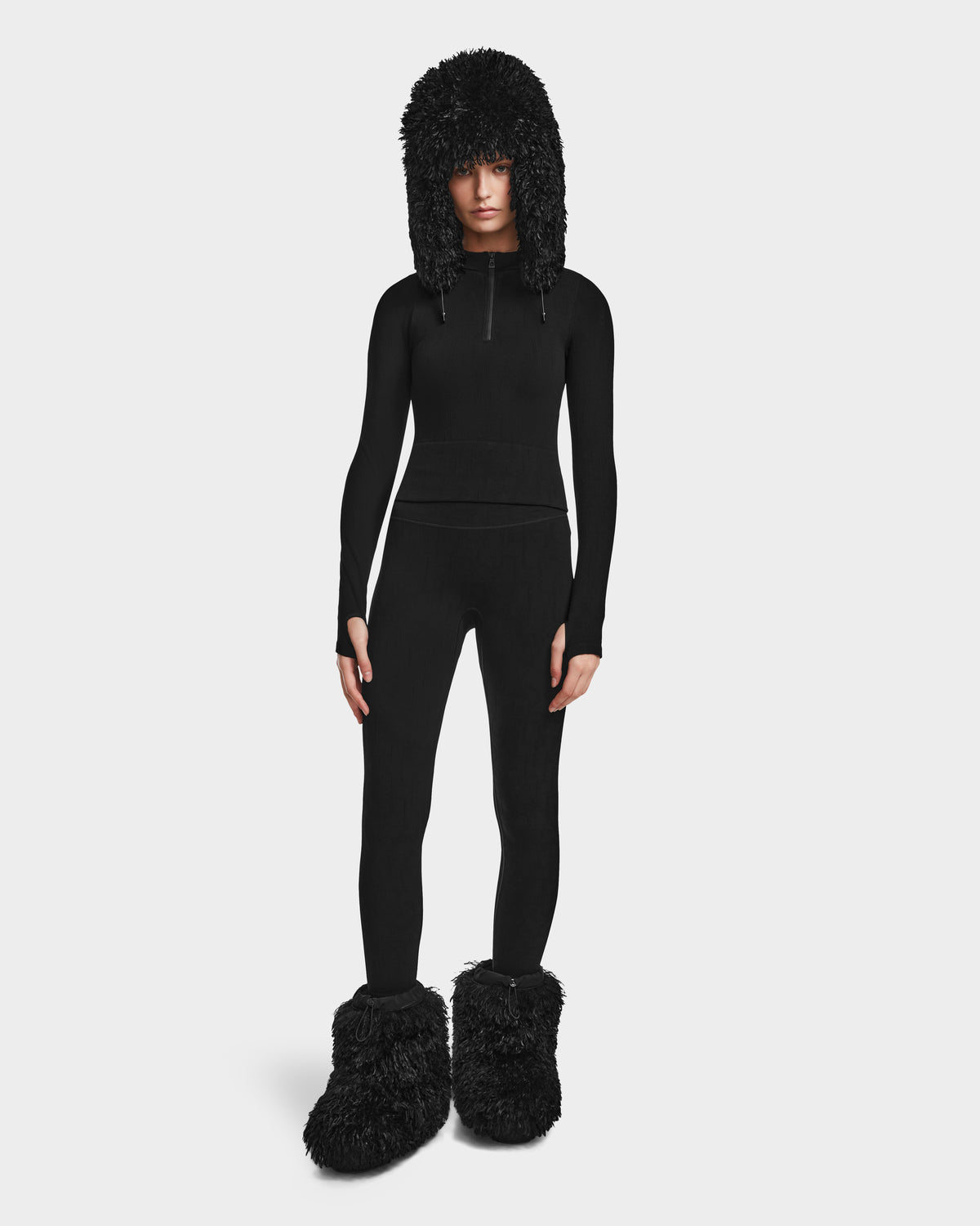 A woman wearing Rudsak’s FERKA - 8524542 Monogram Print Black pull-on leggings, ideal for bringing comfort and style to any winter wardrobe.