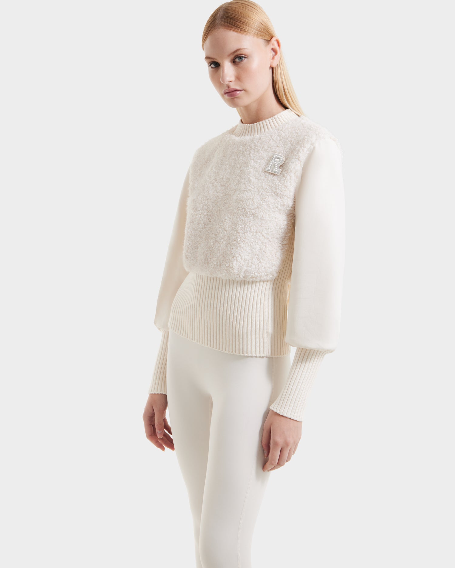 A woman with straight blonde hair models the Rudsak FLORENCE - 8525546 Iceland off-white textured knit top and matching fitted pants, standing against a plain light background.