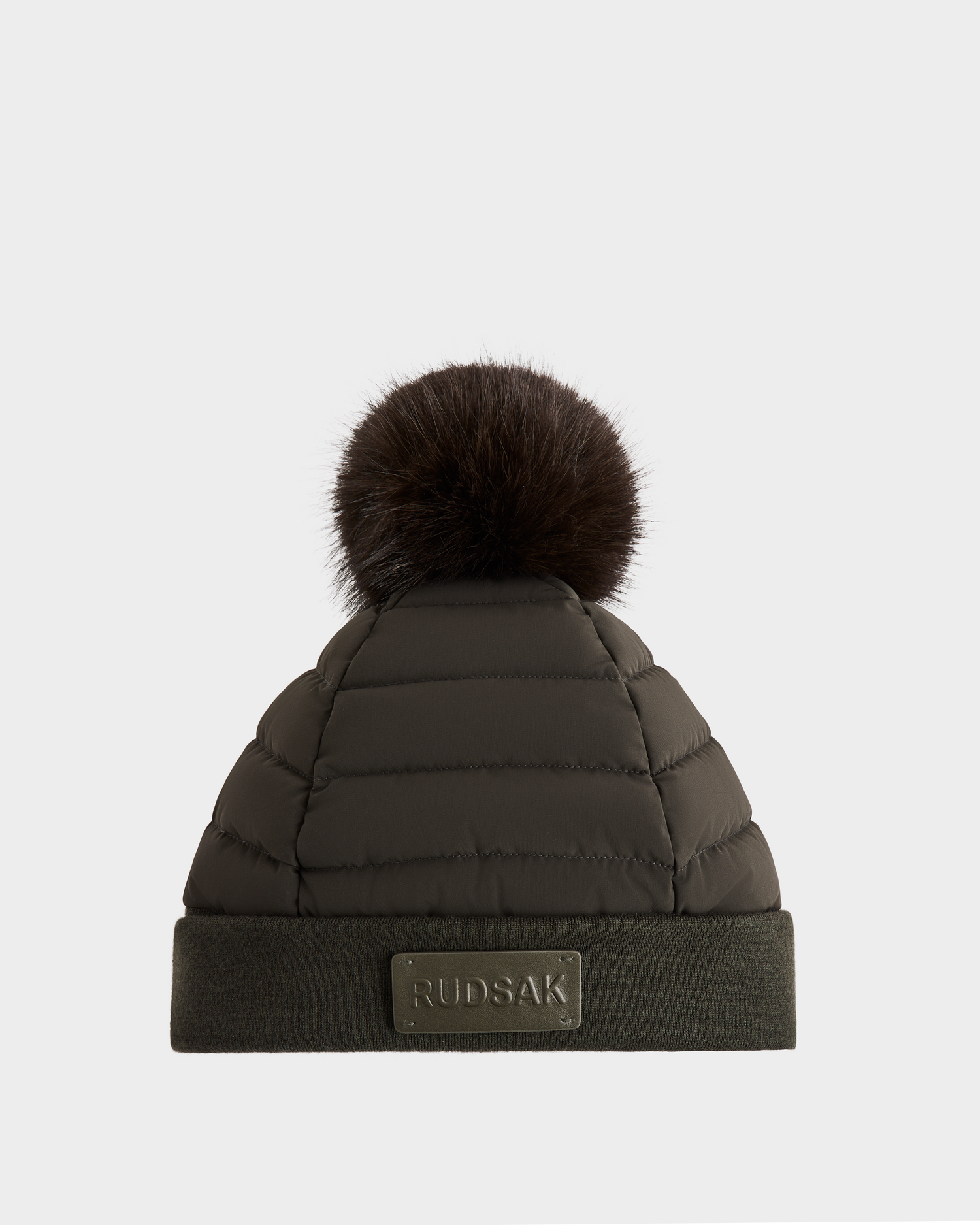 The GALA - 8424514 Dark Olive by Rudsak is a women’s quilted down puffer hat with a large removable faux fur pom-pom and folded brim featuring the Rudsak label—your perfect go-to winter accessory.