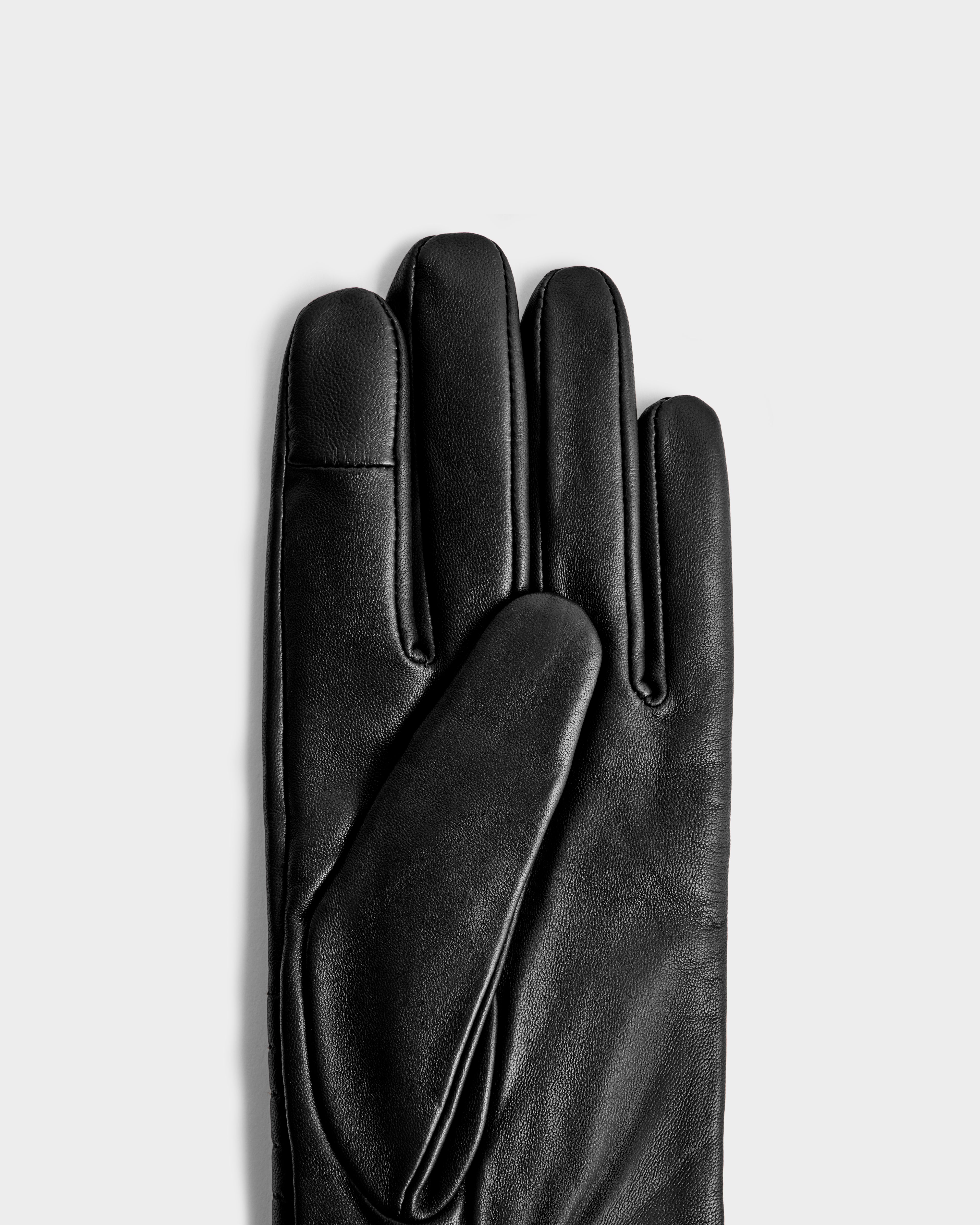 The GEMMA - 8425008 Black glove by Rudsak, a classic winter accessory, is shown palm side up on the left against a plain light gray background.