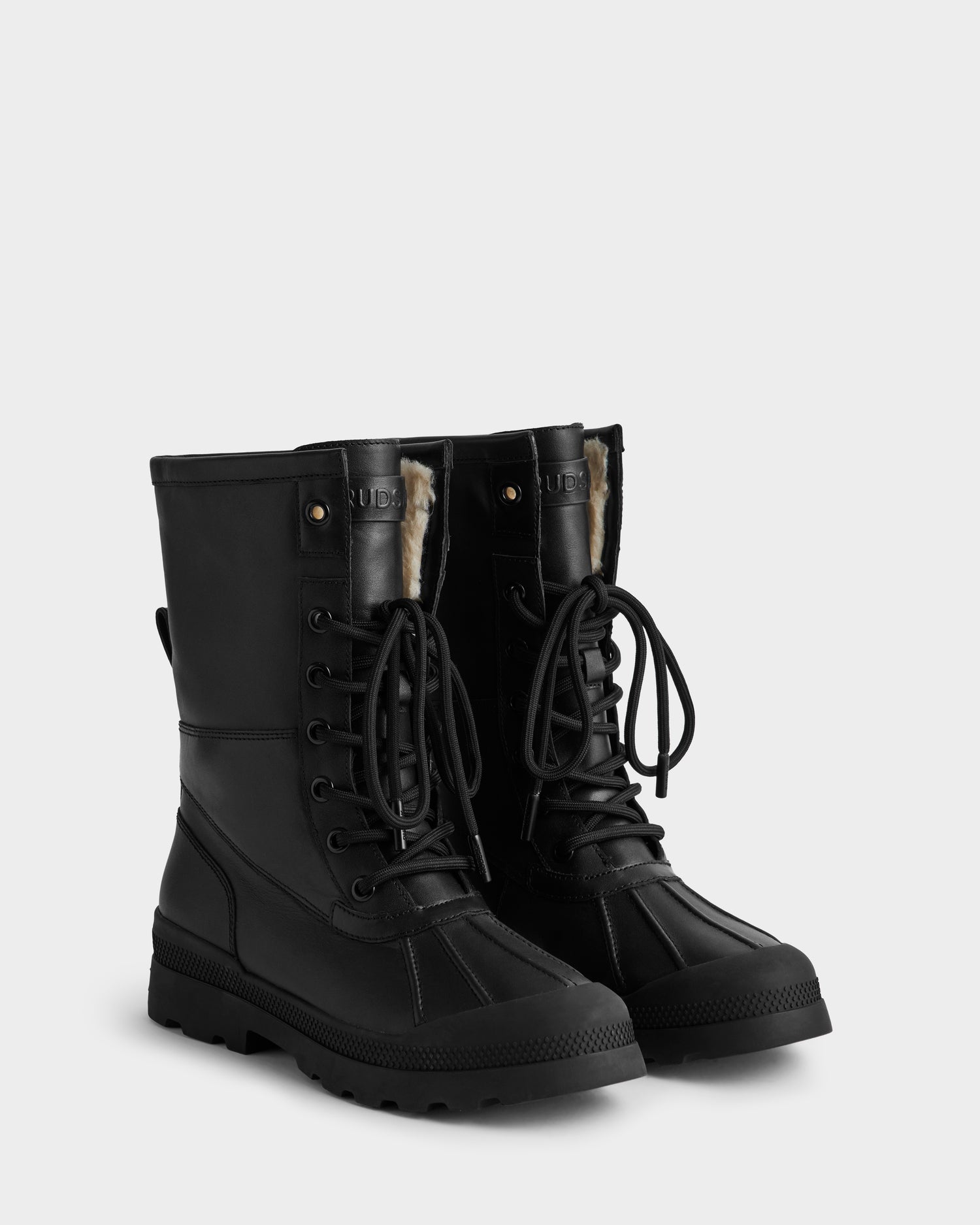 The JESI - 8225026 Black by Rudsak are black lace-up winter boots with rugged soles, reinforced toe caps, and faux fur lining visible at the top, shown against a plain light background.