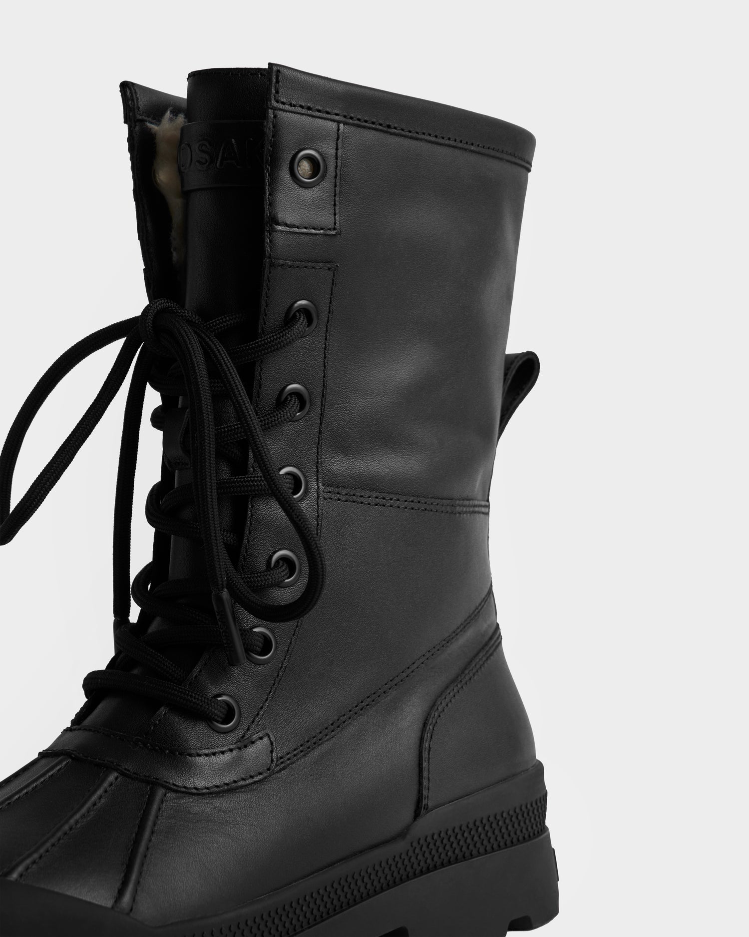 A close-up of the Rudsak JESI - 8225026 Black boot features black laces, metal eyelets, and a thick rubber sole against a plain white background, with only the left side fully visible.