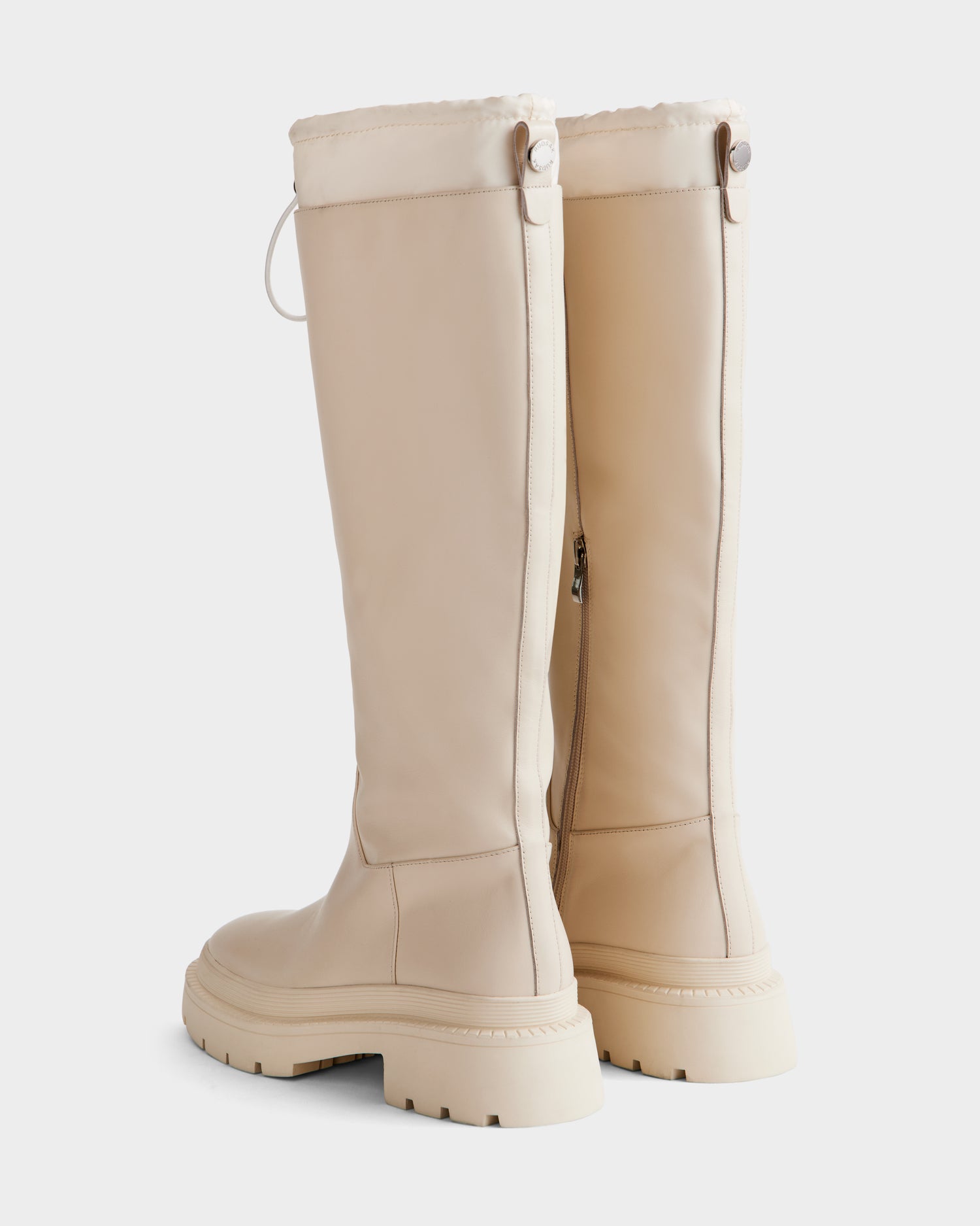 The KAROL - 8225576 Vanilla by Rudsak are knee-high, beige leather women’s boots with chunky rubber soles, visible stitching, side zippers, and an adjustable cuff with drawstring, shown upright against a white background.
