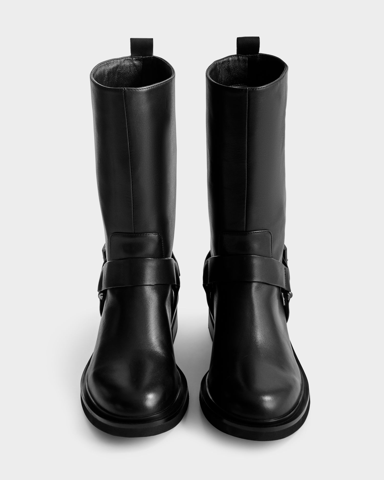A pair of tall black KIRRA - 8225558 women's fashion boots by Rudsak, featuring a strap and buckle detail at the ankle, shown from above on a plain white background.