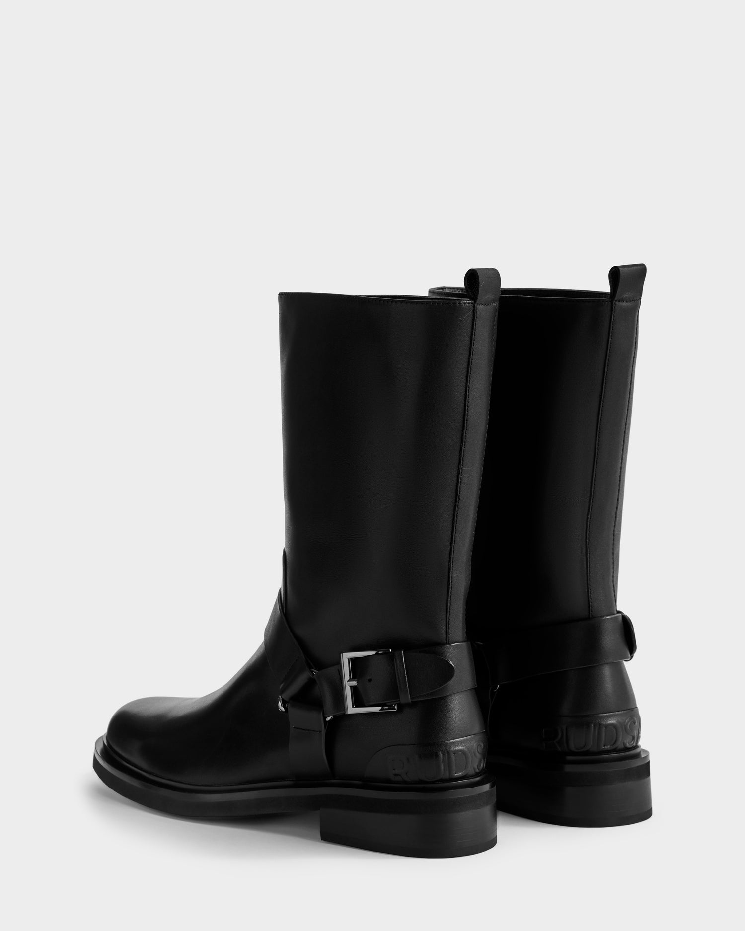 The KIRRA - 8225558 Black moto boots by Rudsak feature silver side buckles, thick soles, and pull tabs, shown from a back-side angle on a plain white background.