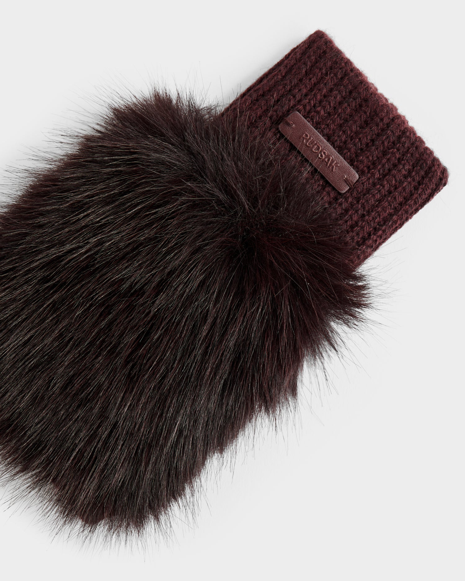 The LIA - 8425007 Bordeaux by Rudsak is a women’s fingerless mitten in burgundy wool-blend knit with a large faux fur cuff and a small leather tag showing the brand name, set against a plain background.