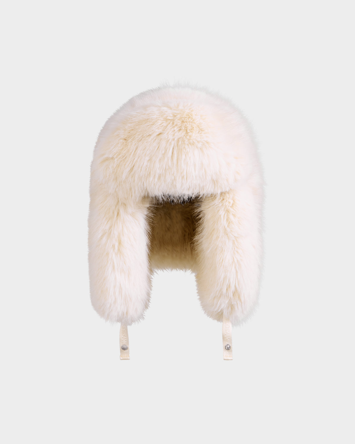 The Rudsak LIRA - 8425024 Vanilla is a women’s fluffy white faux fur aviator hat with ear flaps and chin straps, designed for cozy winter warmth, shown against a plain light gray background.