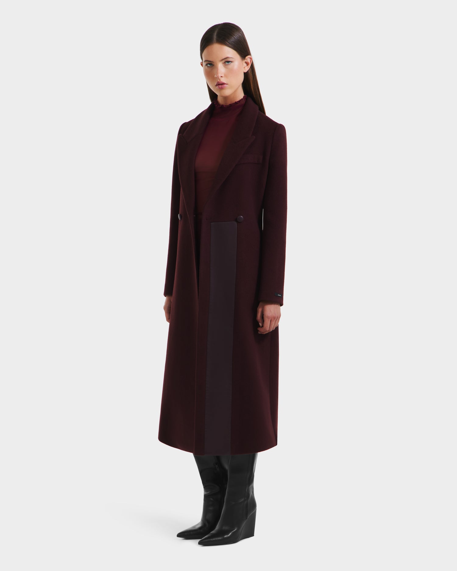 A woman in the Rudsak LYNWOOD - 8125539 Bordeaux premium wool coat with a leather front panel.