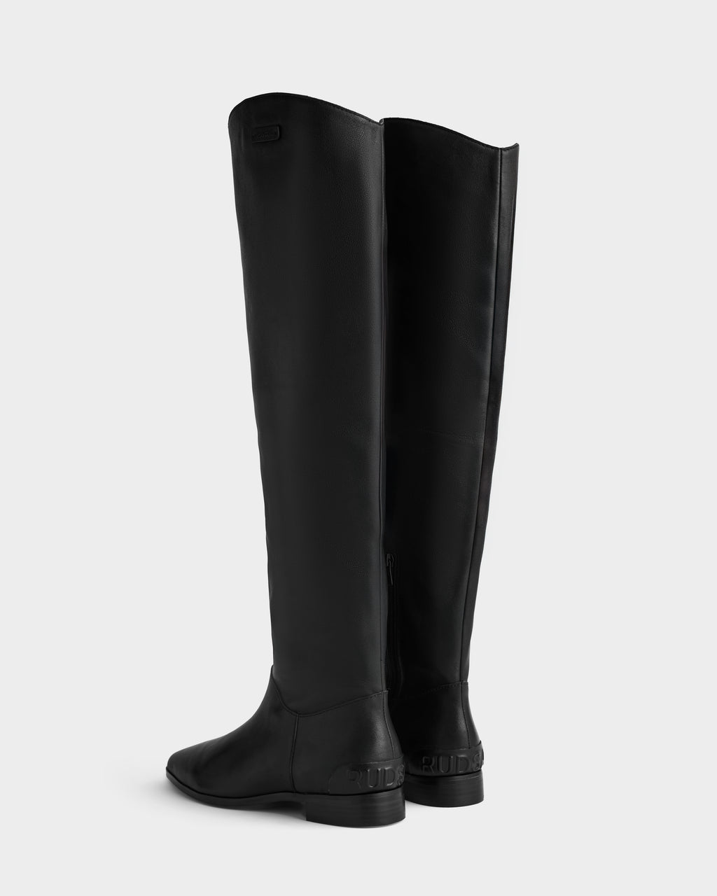 The MARSALLA - 8225033 Black women’s high-shaft leather boots by Rudsak feature low heels and a tall black silhouette, shown from the back and side against a plain white background.