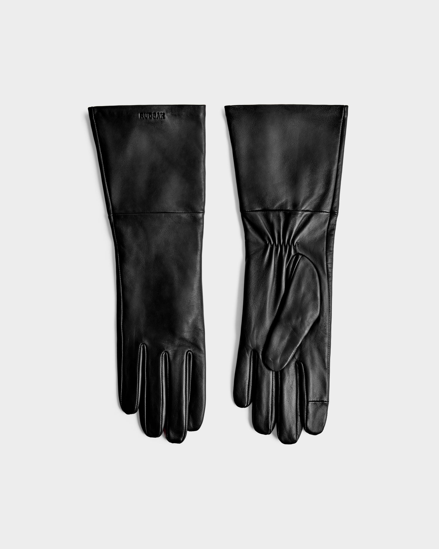 The MEGAN - 8425541 Black leather gloves by Rudsak are displayed flat on a light gray background, with one showing the palm and the other the back—a timeless women’s accessory.