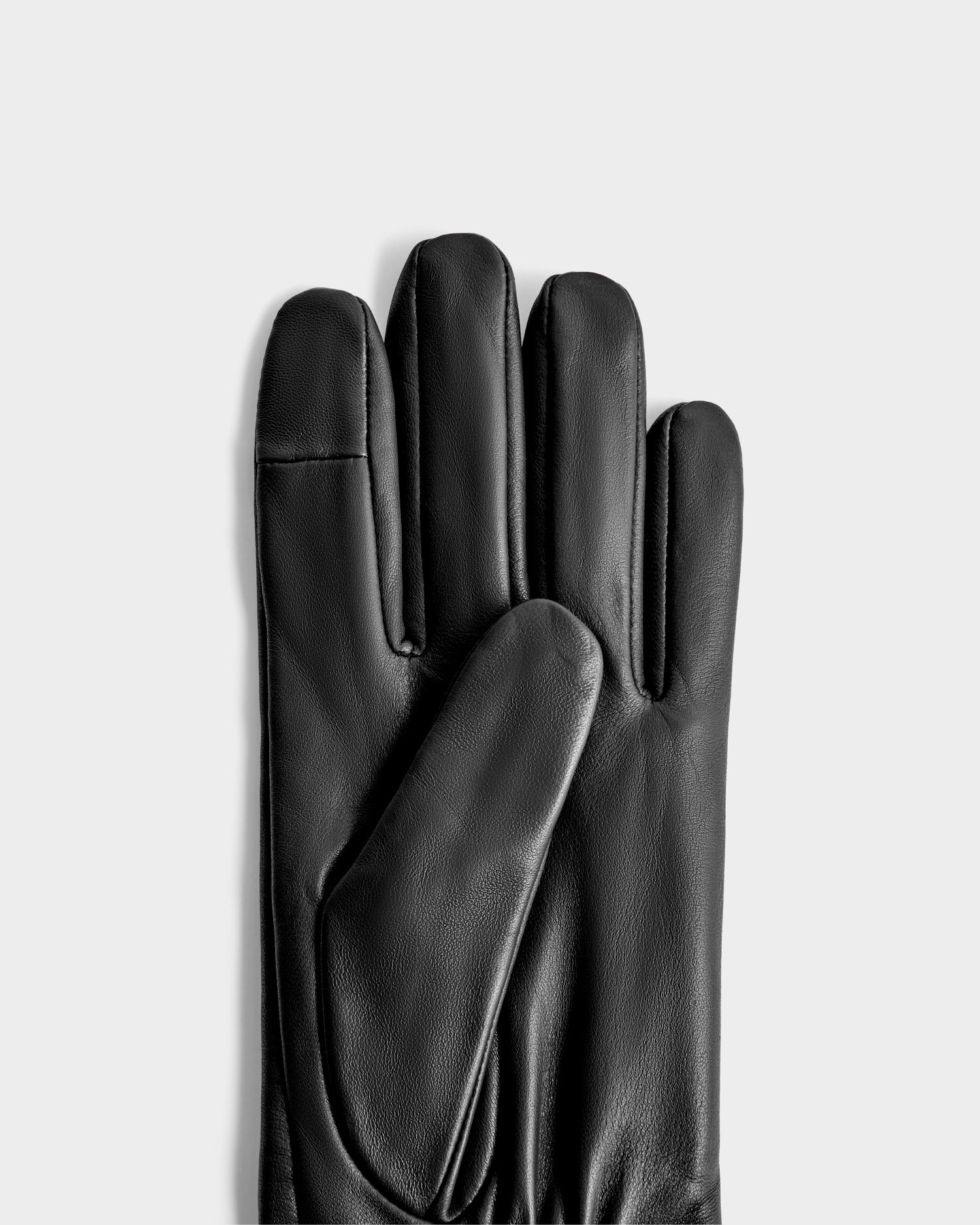 The Rudsak MEGAN - 8425541 Black women's leather gloves, a timeless accessory, are displayed with one glove partly overlapping the other on a light gray background.