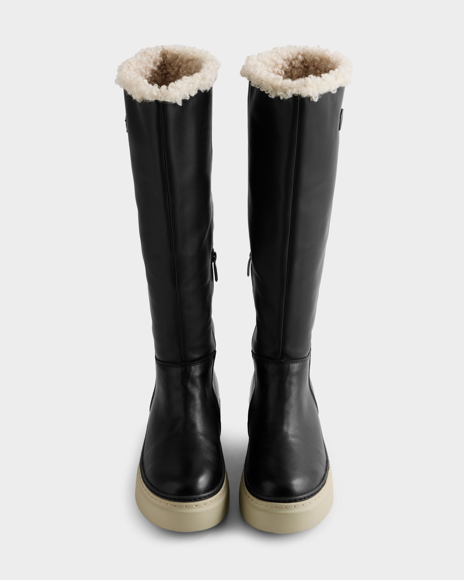 The MIKIE L - 8225580 Black boots by Rudsak are tall black leather boots with white shearling trim and thick light rubber soles, displayed upright on a plain white background.