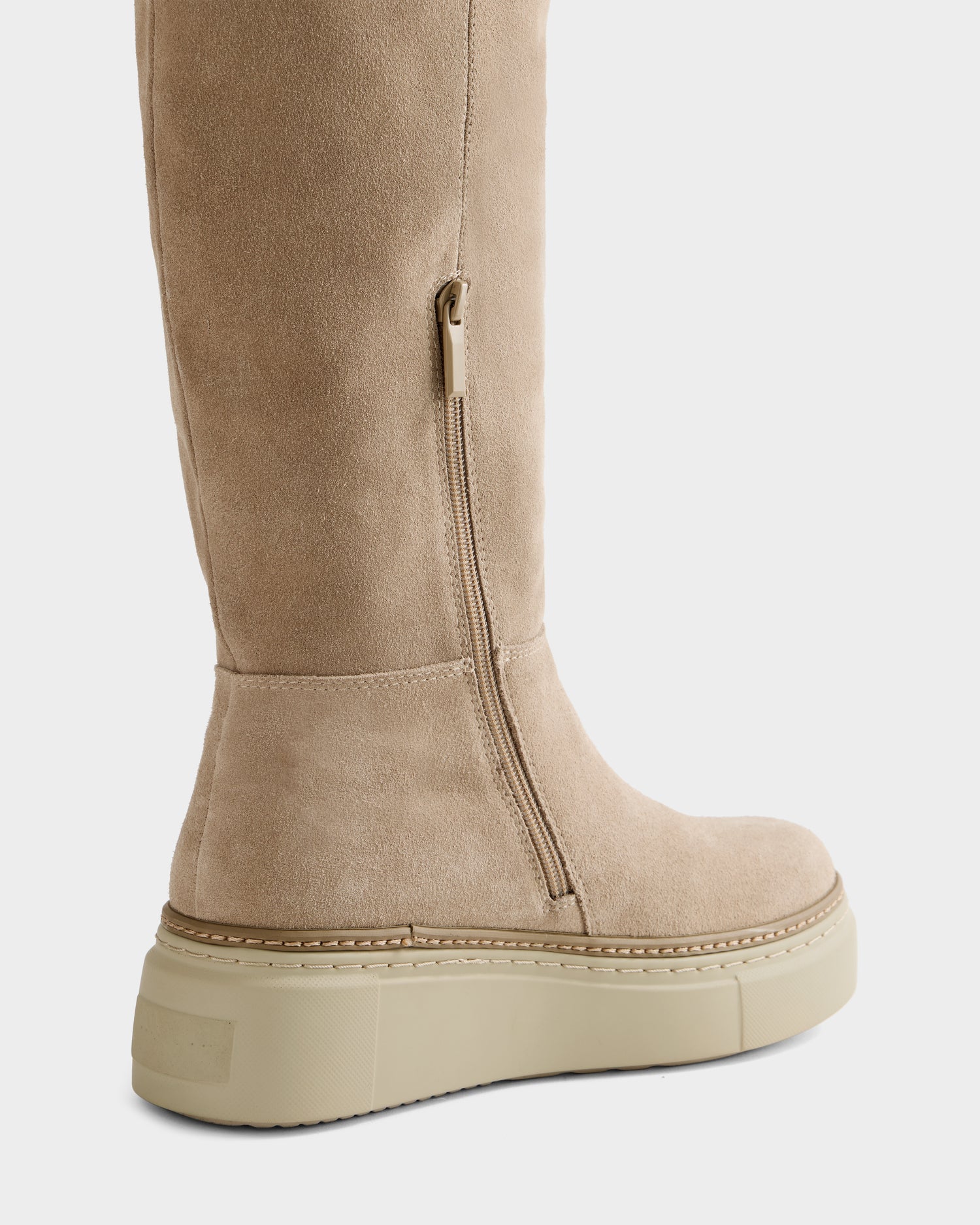 Close-up of the Rudsak MIKIE - 8225579 Almond knee-high boot in beige suede, featuring a side zipper and thick light-colored platform sole.