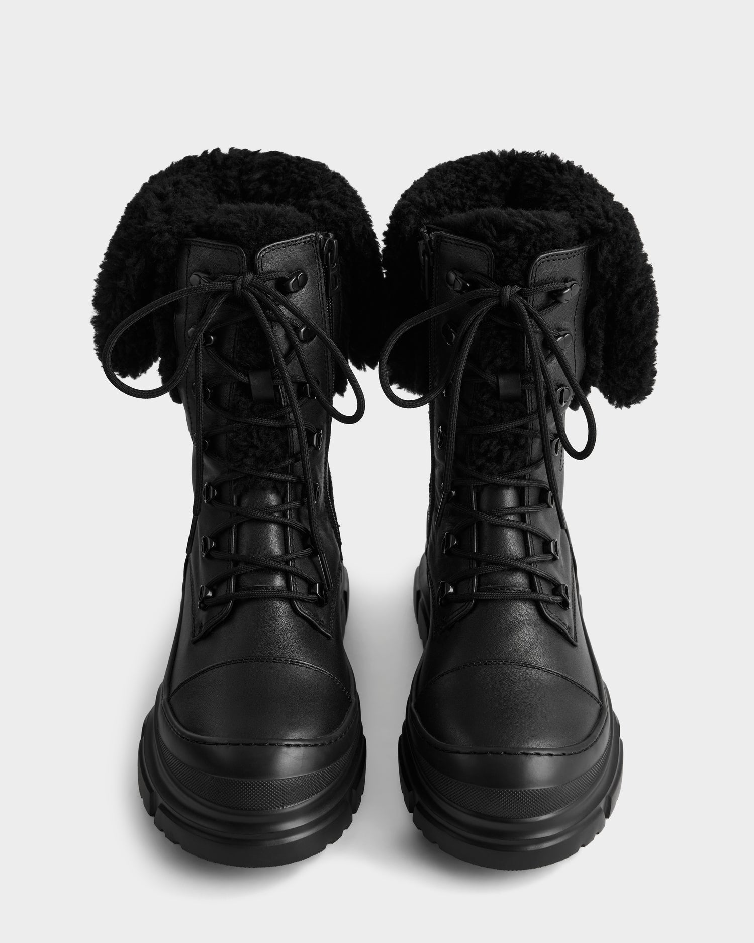 The MODENA - 8225024 Black combat boots by Rudsak feature thick soles and folded-over black faux shearling lining, shown upright and facing forward on a plain light background.