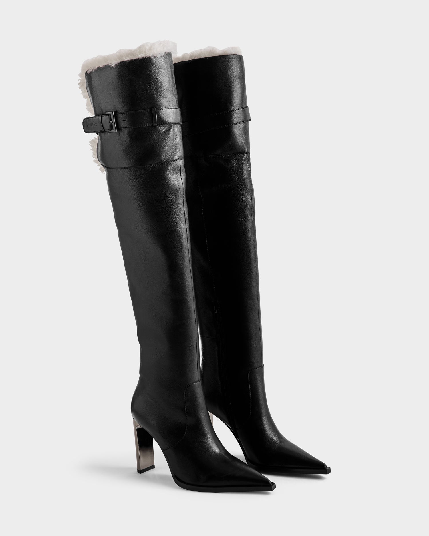 The Rudsak PERNA - 8225555 Black boots feature tall leather shafts, black high heels, pointed toes, top side buckles, and visible white shearling lining—stylish winter statement footwear.
