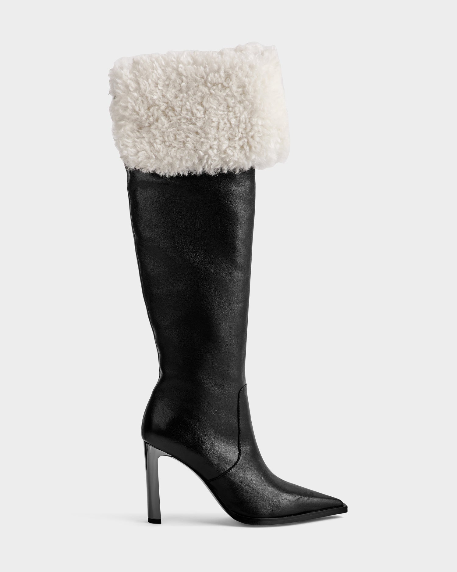 The PERNA - 8225555 Black by Rudsak is a high-heeled, knee-high boot with a pointed toe and thick white shearling cuff—perfect for winter and strikingly stylish against a plain light gray background.