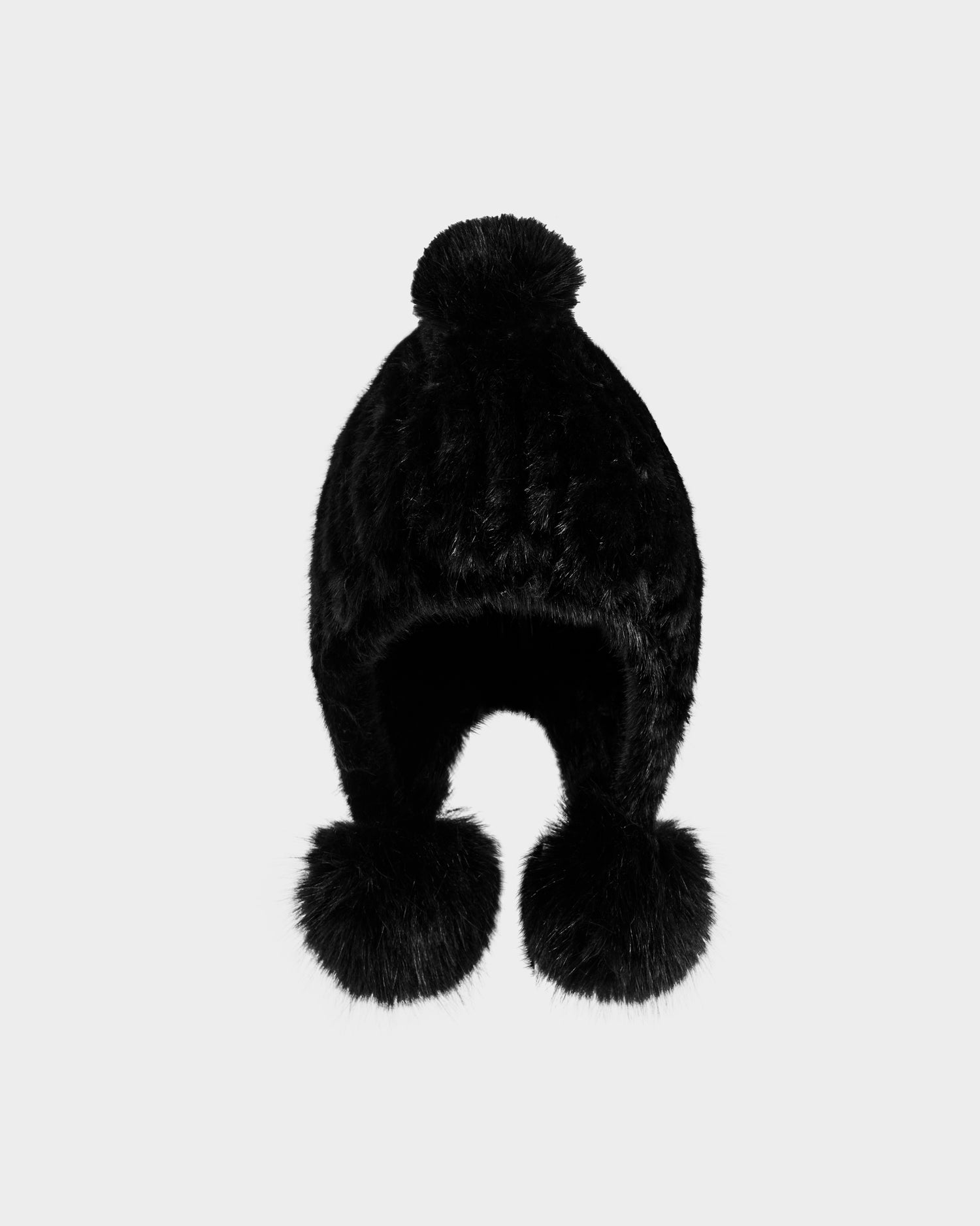 The Rudsak PIA - 8425547 Black women's faux fur hat features ear flaps and three large pom-poms—one on top and one at each end—making it a cozy winter accessory, shown against a plain light background.