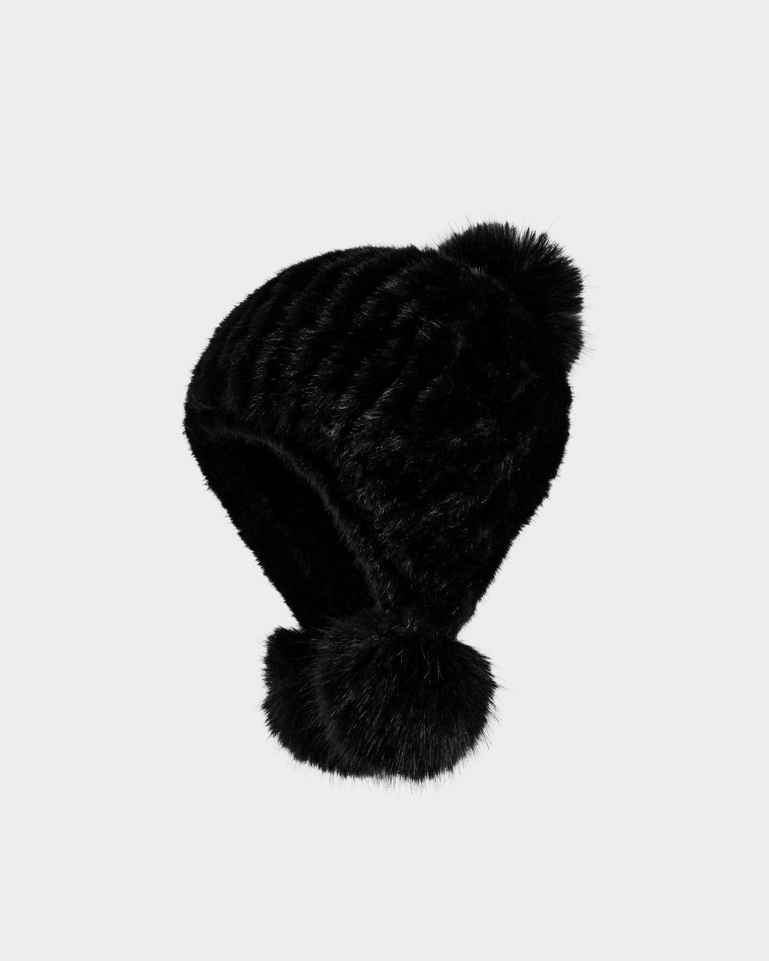 The Rudsak PIA - 8425547 Black women’s faux fur hat features two large pom-poms, one on top and one at each ear flap, and is displayed against a plain light grey background—an essential winter accessory.