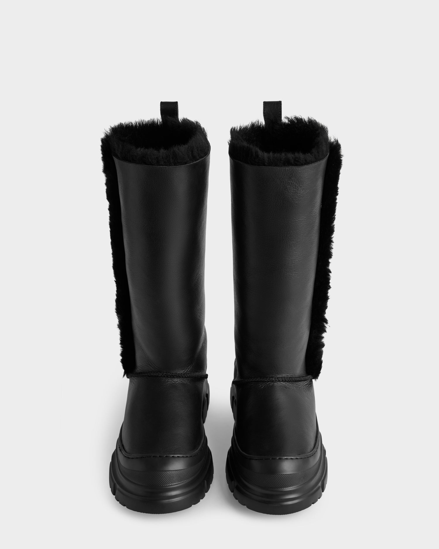 The Rudsak RAVENNA - 8225031 Black women’s winter boots feature chunky soles and black faux fur lining, shown from the front against a plain light background.