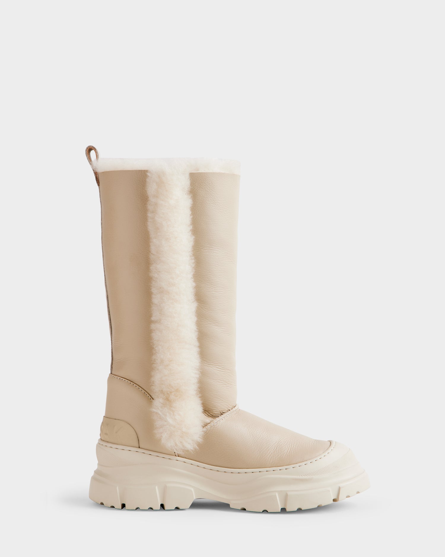 The Rudsak RAVENNA - 8225031 Vanilla is a beige women’s winter boot with a chunky sole and a vertical white faux fur strip along the side, inspired by Rudsak’s signature leather shearling design, shown on a plain white background.