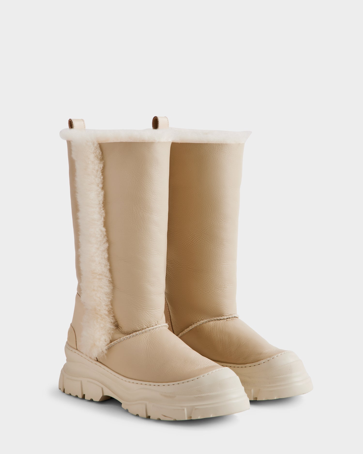 The Rudsak RAVENNA - 8225031 Vanilla women’s winter boots feature beige uppers, chunky white soles, round toes, and plush white faux fur lining visible along the top and side seams.