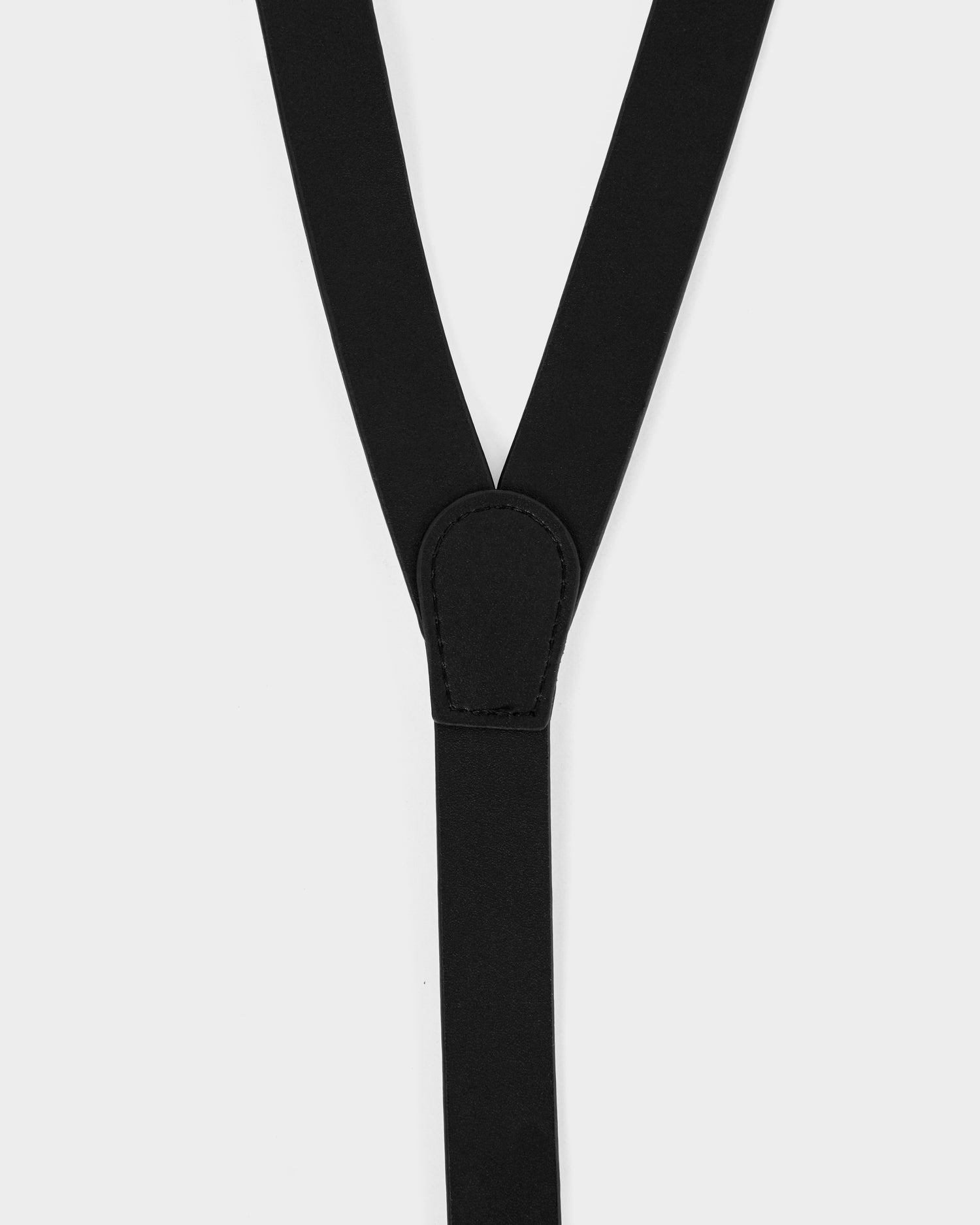 Close-up of Rudsak's RAYNA - 8425539 black suspenders, featuring a stitched leather patch at the strap junction, set against a white background.