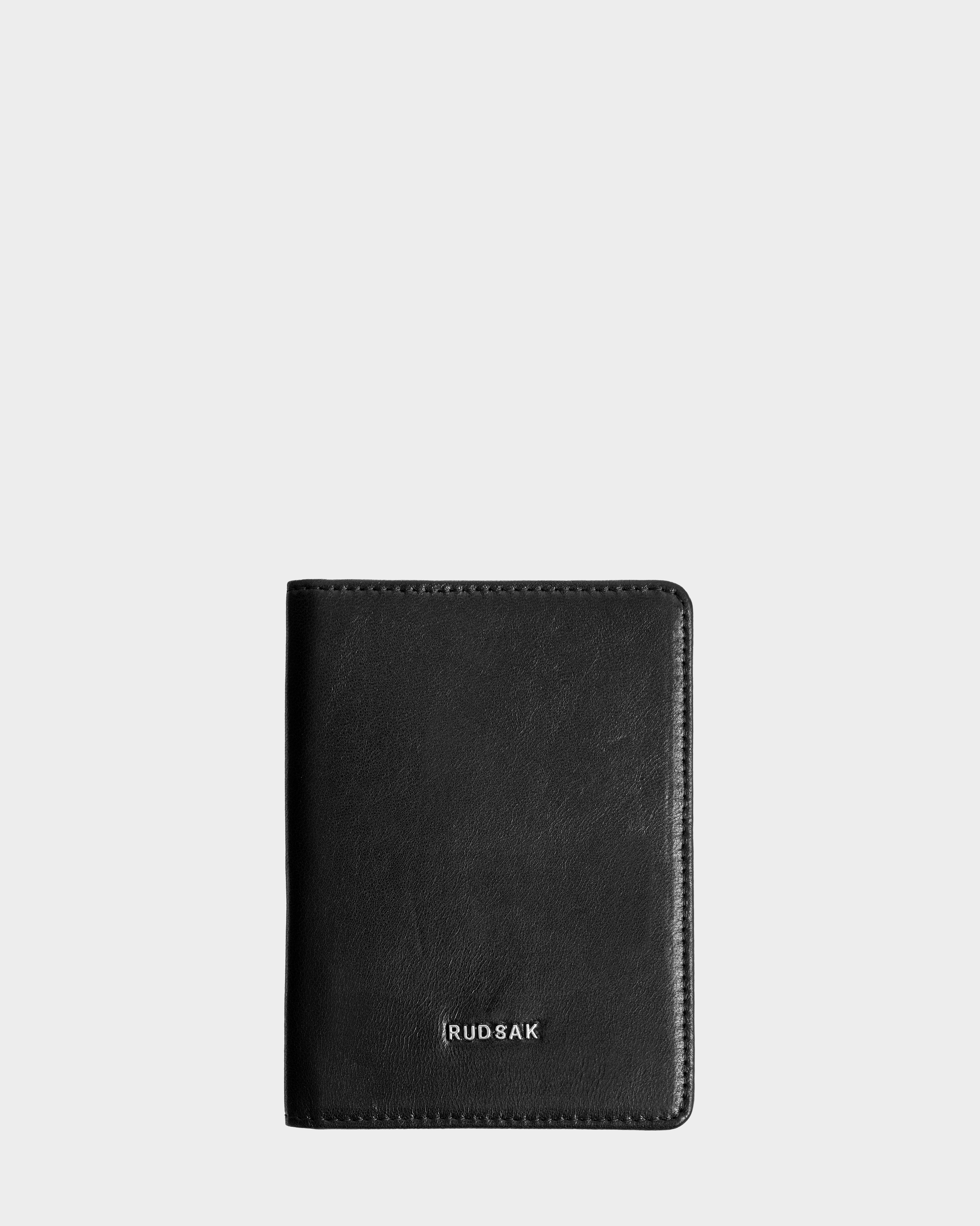A closed black leather wallet, ROBIN - 9425562 Black by Rudsak, with the brands name embossed in silver near the bottom, displayed against a plain light gray background.