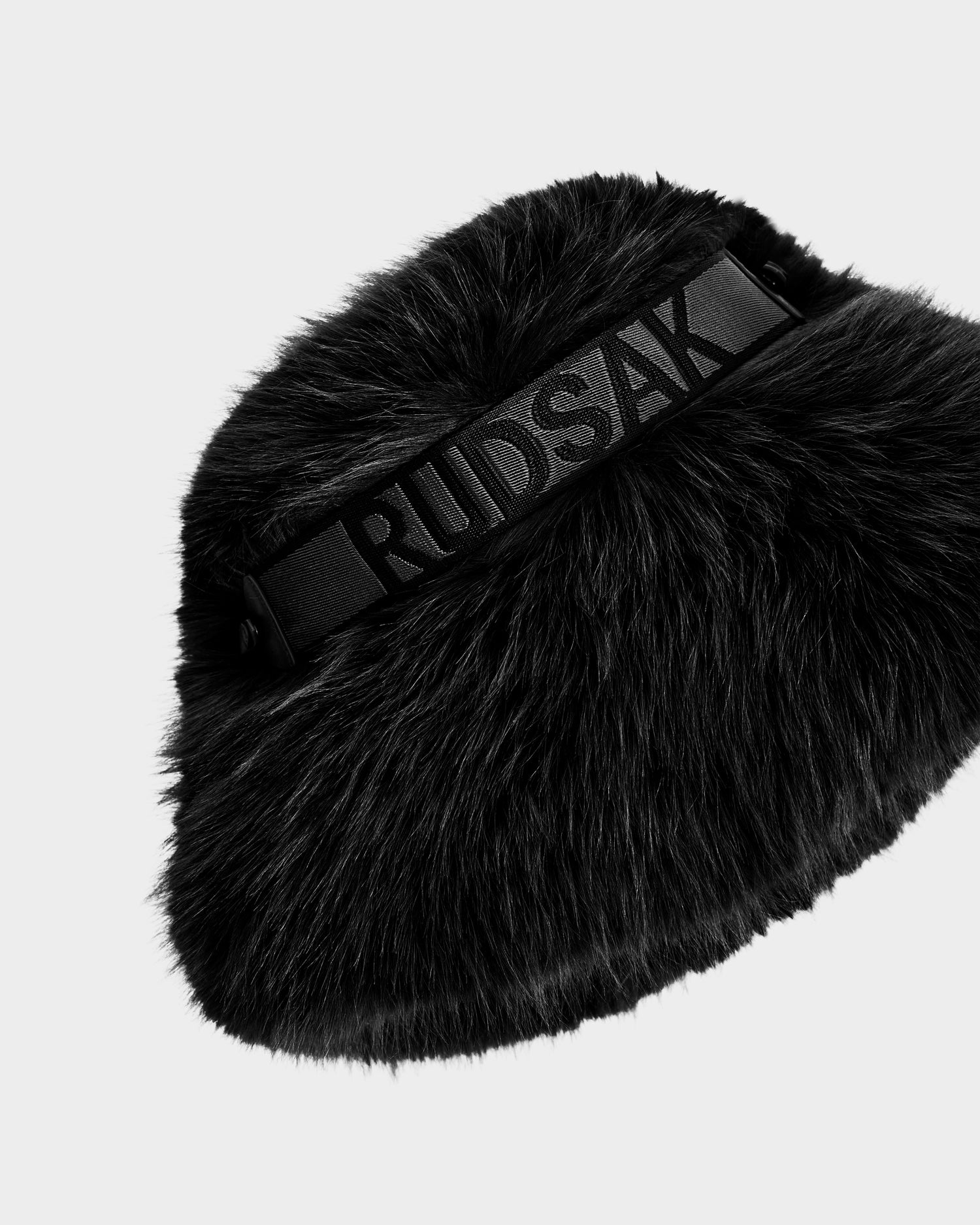 The ROMINA - 8425545 Black by Rudsak is a cozy-luxe black faux fur bucket hat with a wide elastic band featuring bold RUDSAK lettering, designed for standout style.