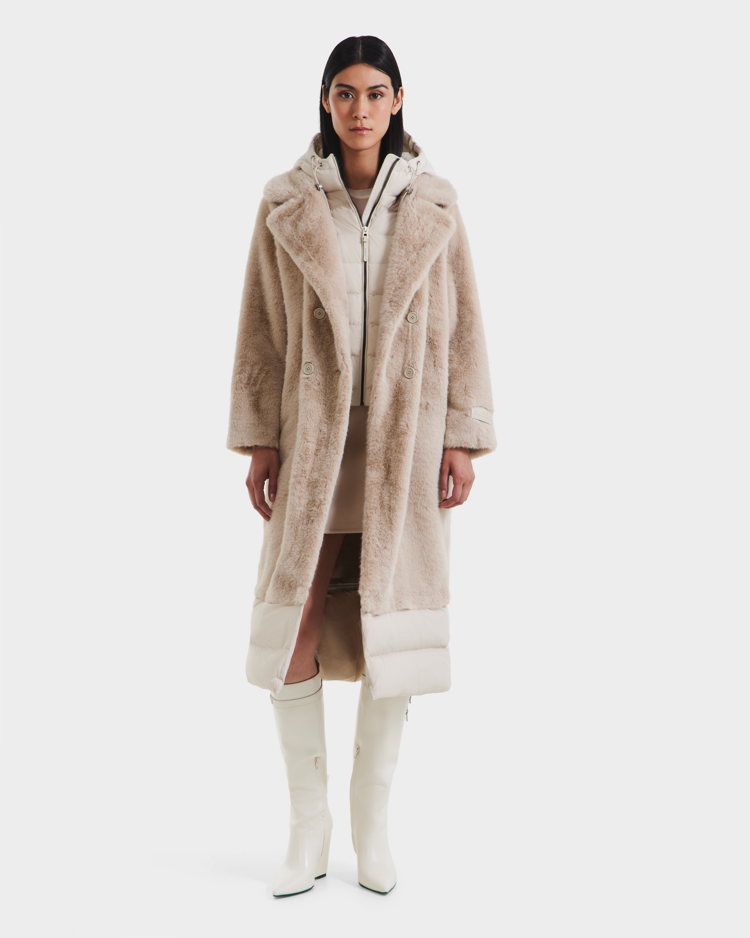 A woman stands facing forward wearing the Rudsak SIENA - 8125542 Vanilla faux fur coat over a cream dress, paired with knee-high white boots, against a plain white background.