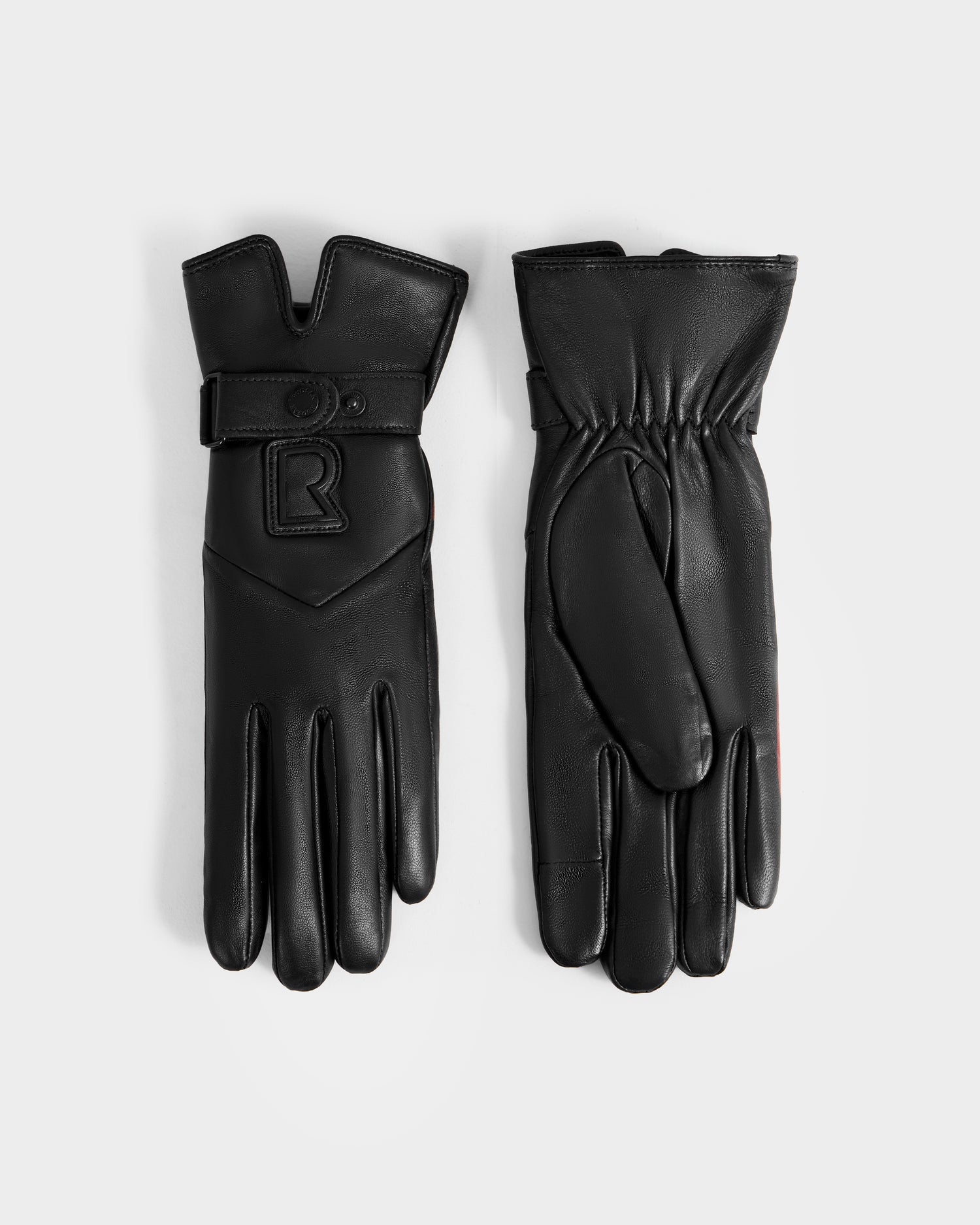 The Rudsak STROMBOLI - 8424510 Black women's leather gloves are shown on a white background: one displays the front with a strap and R logo, the other the back with gathered elastic at the wrist. They are touchscreen compatible.