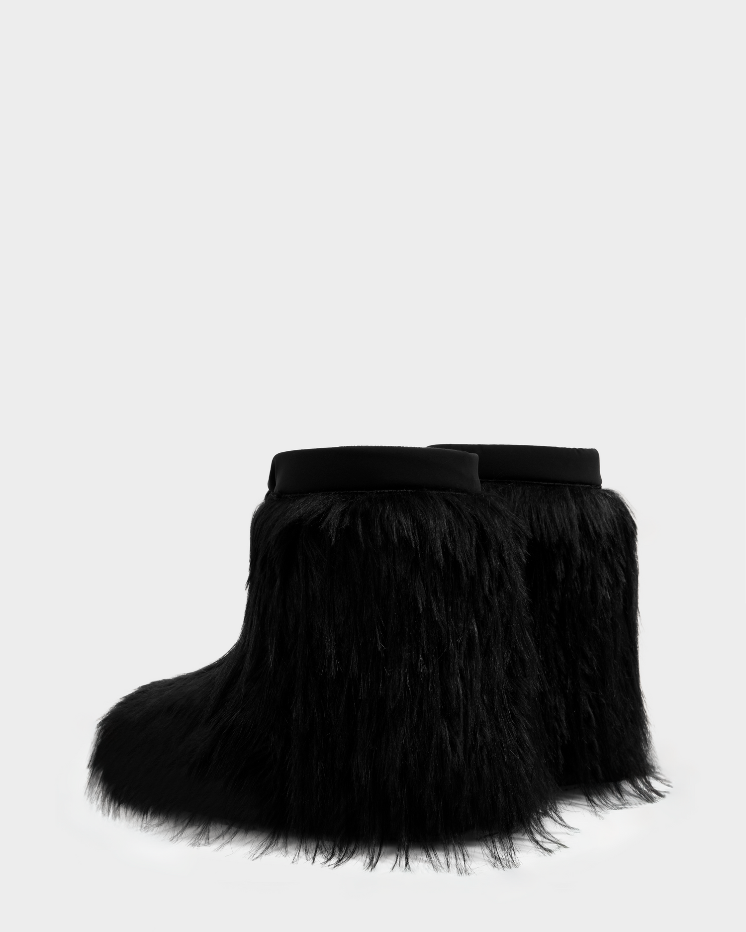 The SUZIE G - 8225545 Black boots by Rudsak are mid-calf après-ski boots in black, fully covered in long, shaggy faux fur with a smooth band at the top, shown against a plain light gray background.