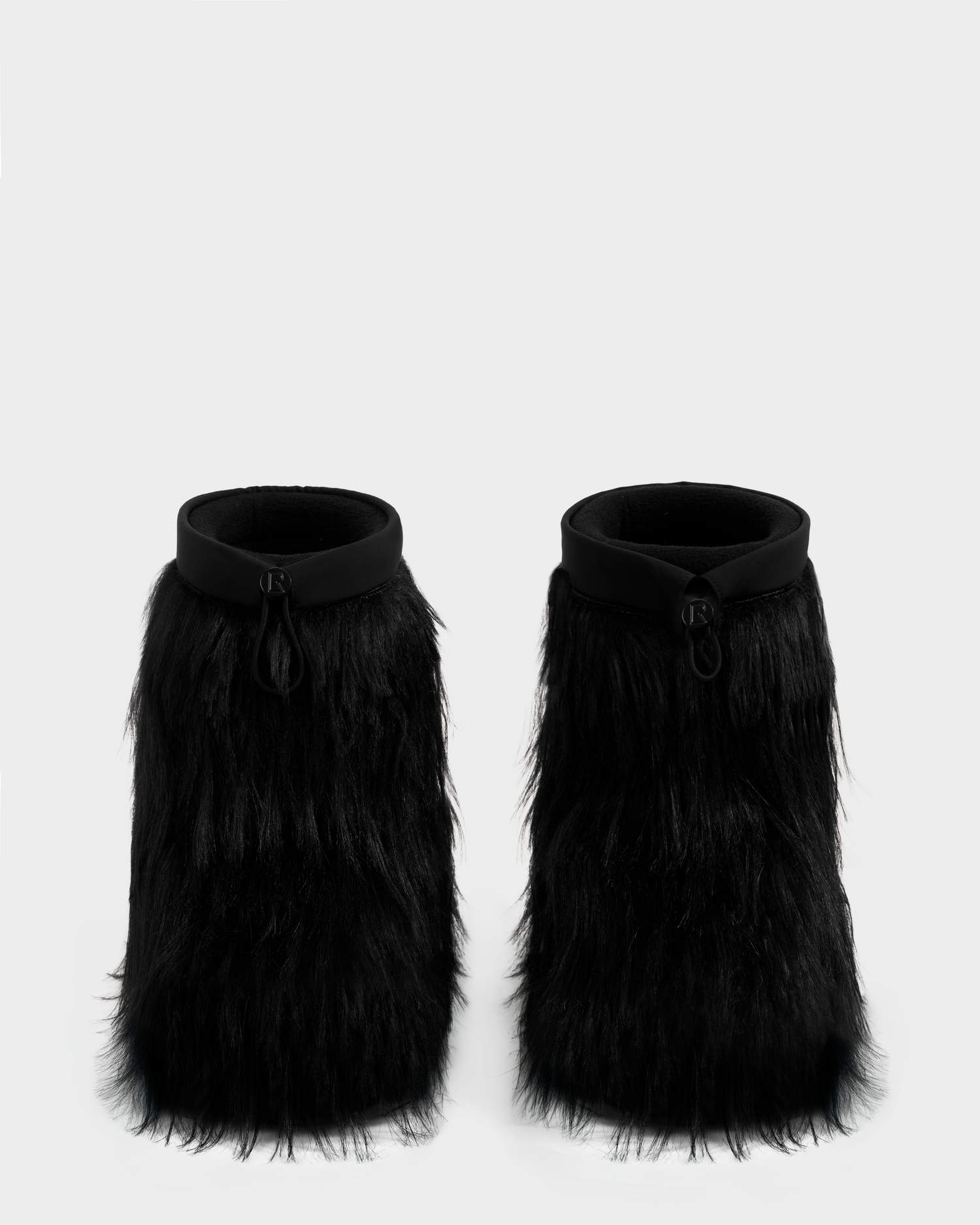 The Rudsak SUZIE G - 8225545 Black boots feature thick, shaggy black fur, an ankle-high silhouette, and a rounded collar, displayed side by side on a plain background.