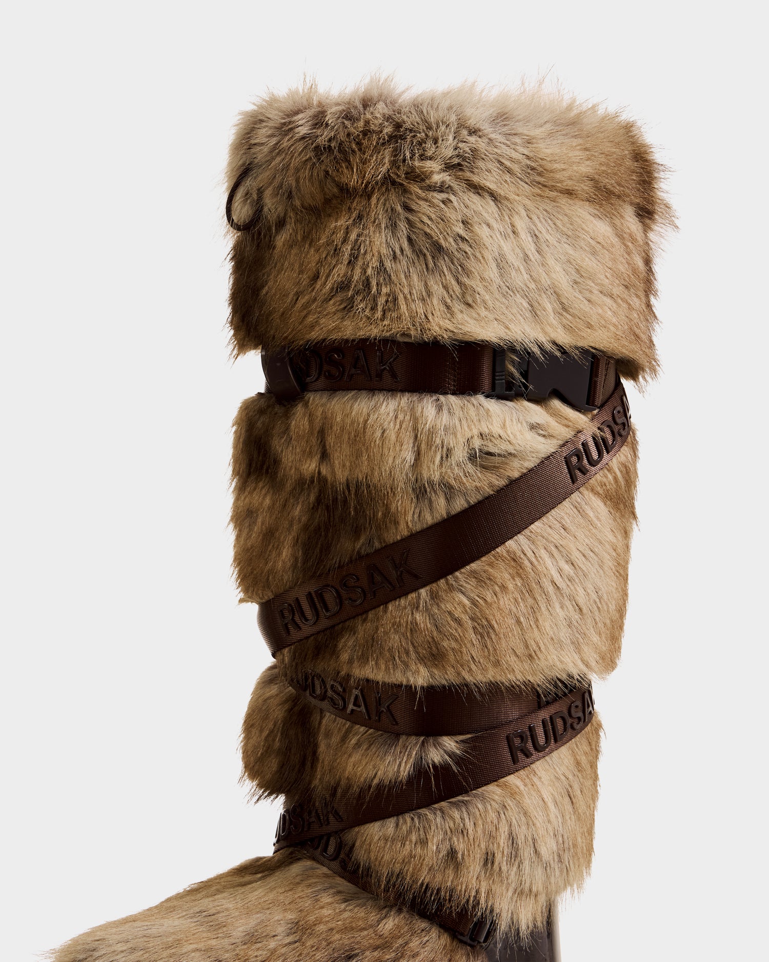 The TORIN - 8225029 Mix Mocha by Rudsak is a tall women’s faux fur moon boot in brown, featuring wide embossed leather straps—ideal for après-ski style—displayed against a plain white background.