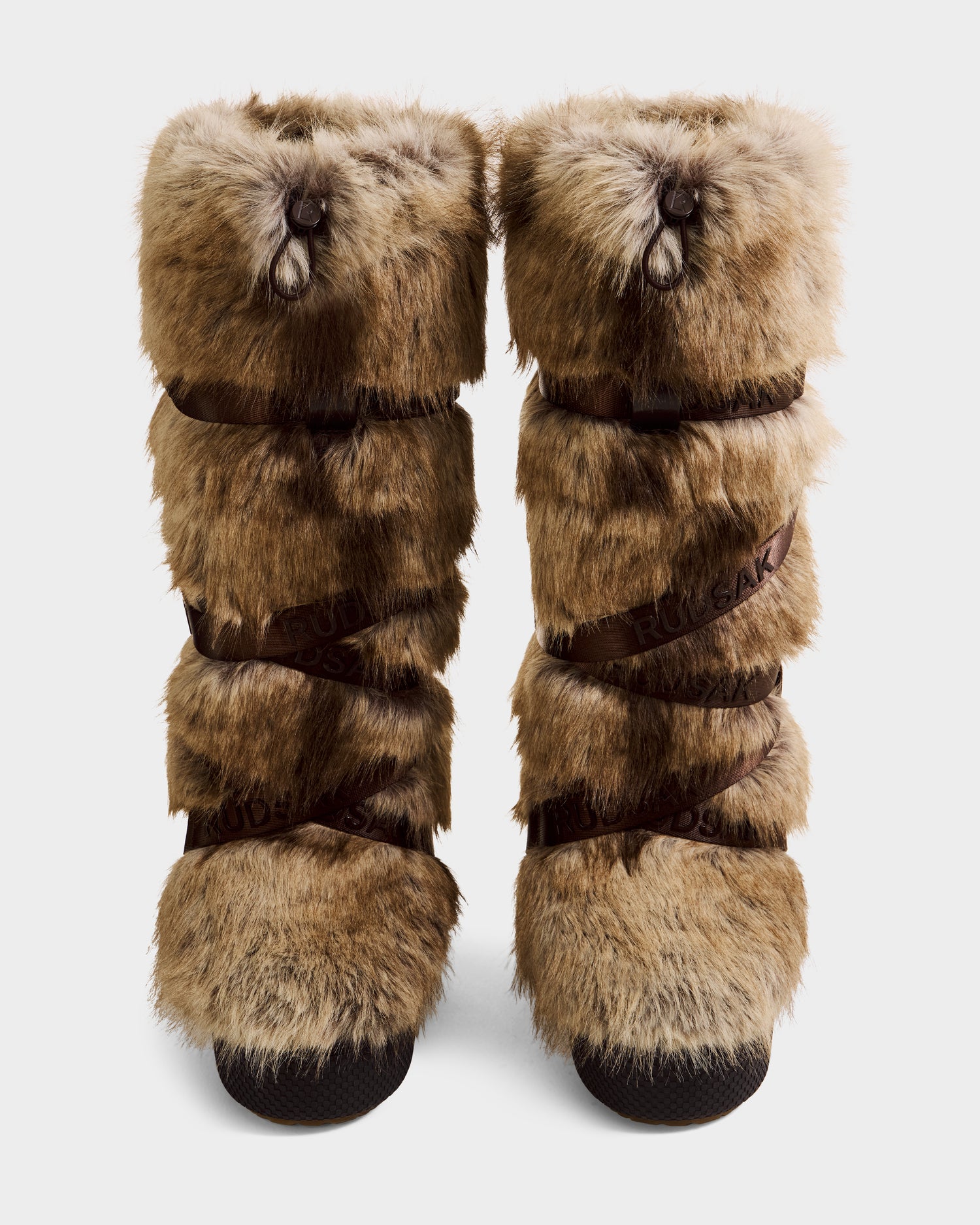 Rudsak TORIN - 8225029 Mix Mocha women’s tall brown faux fur moon boots with black soles and vertical leather straps, shown side by side on a plain white background.