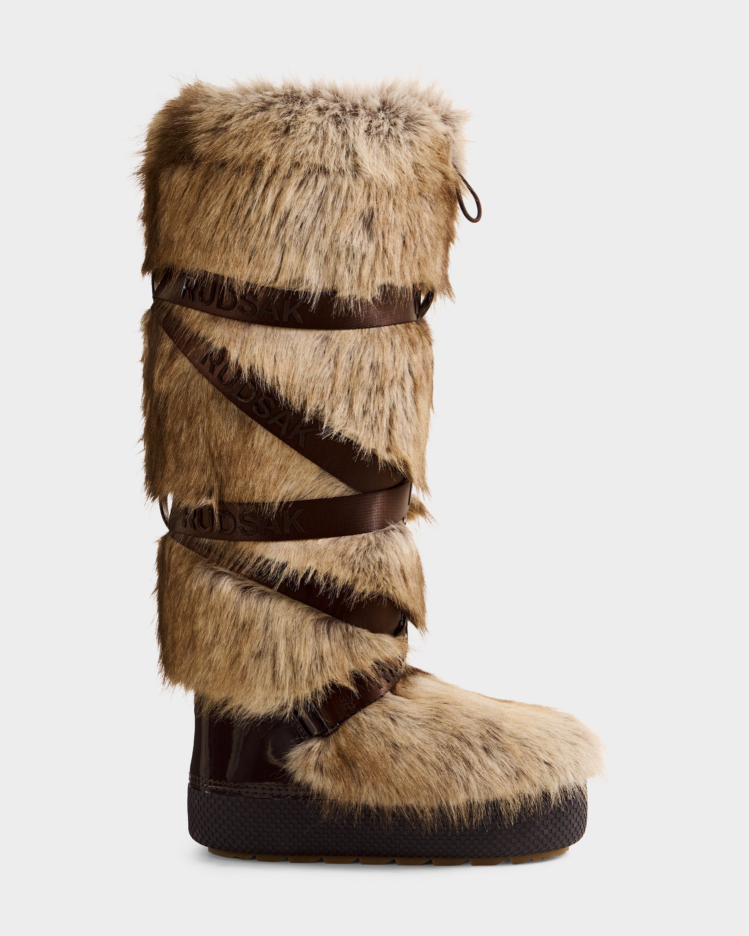 The Rudsak TORIN - 8225029 Mix Mocha is a tall, knee-high women’s moon boot with thick light brown faux fur, dark brown leather crisscross straps, and a sturdy dark rubber sole—ideal for après-ski adventures.