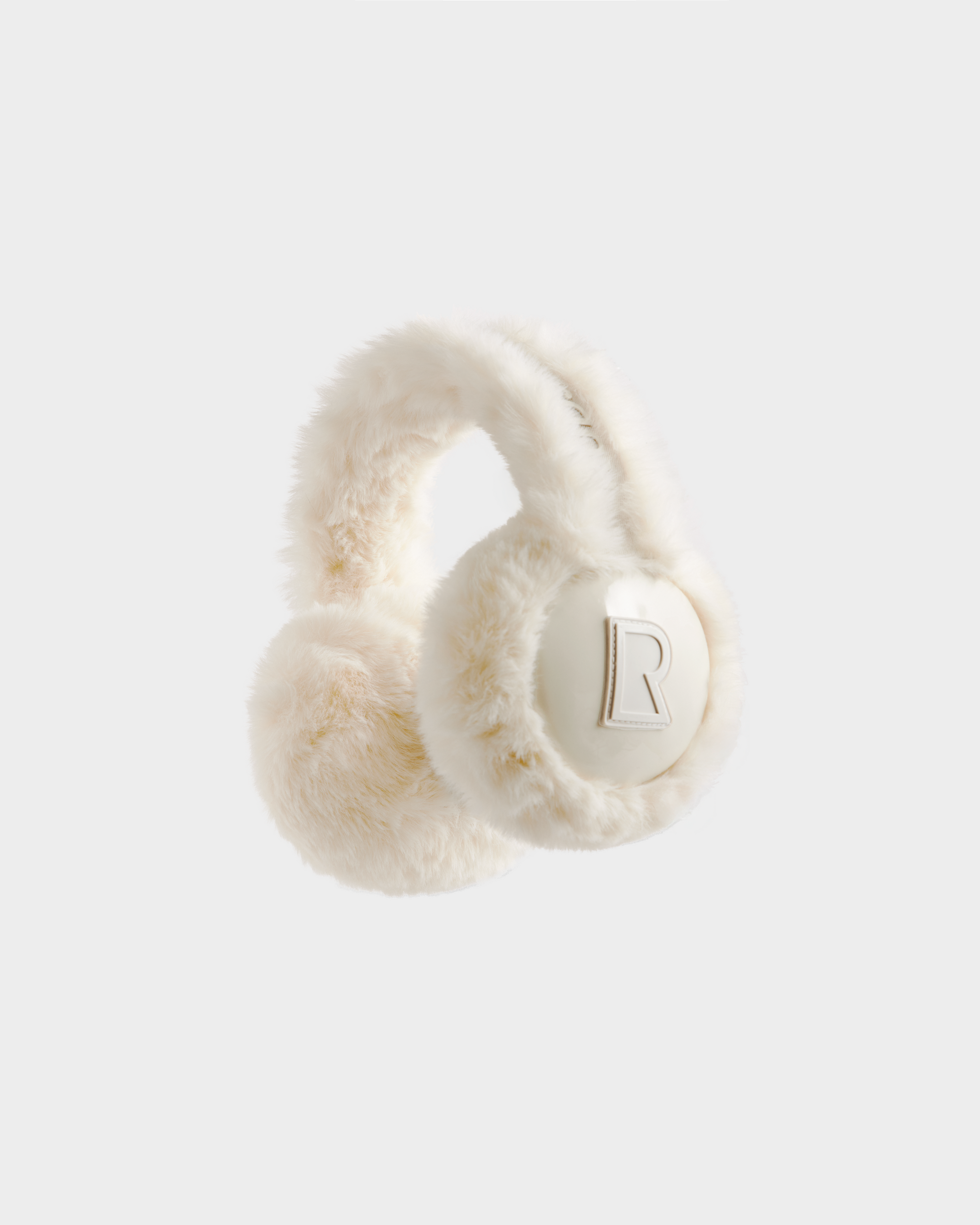 VALENCIA - 8425543 Iceland by Rudsak: cream-colored faux fur earmuffs with a thick, soft headband and the letter R embossed on one ear pad—an ideal winter accessory against a plain light background.