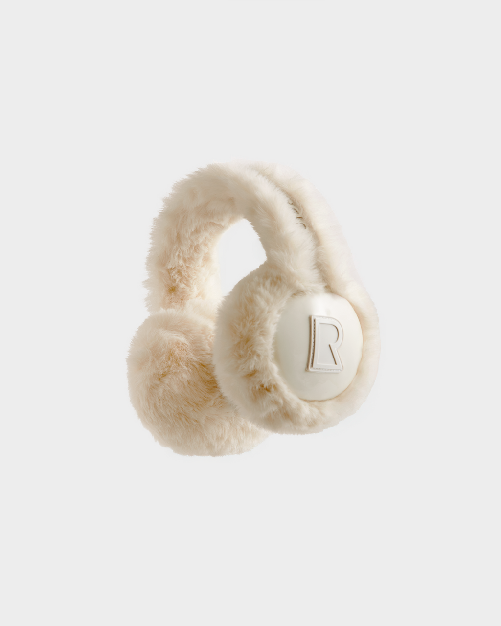VALENCIA - 8425543 Vanilla earmuffs by Rudsak feature cream-colored faux fur, a soft texture, and a bold “R” embossed on one ear pad—all set against a plain white background. A cozy winter accessory perfect for chilly days.