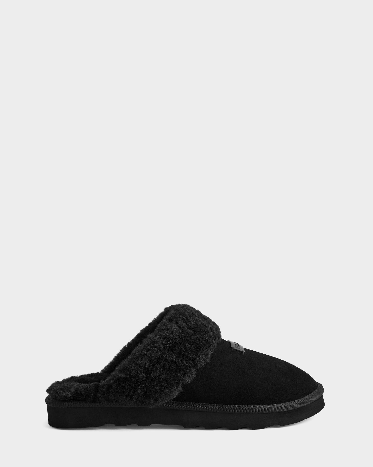 The WILBER - 6225509 Black men’s slipper by Rudsak features black suede, a soft faux shearling lining, and a flat sole, displayed in side profile against a plain light gray background.