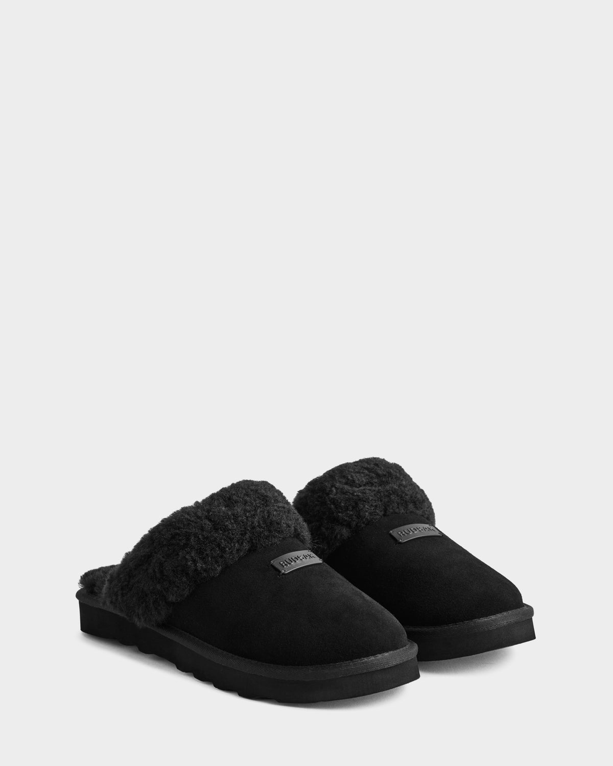 Rudsak’s WILBER - 6225509 Black men’s suede slip-on slippers with plush fur lining and flat soles are perfect for cozy loungewear, shown on a light gray background.