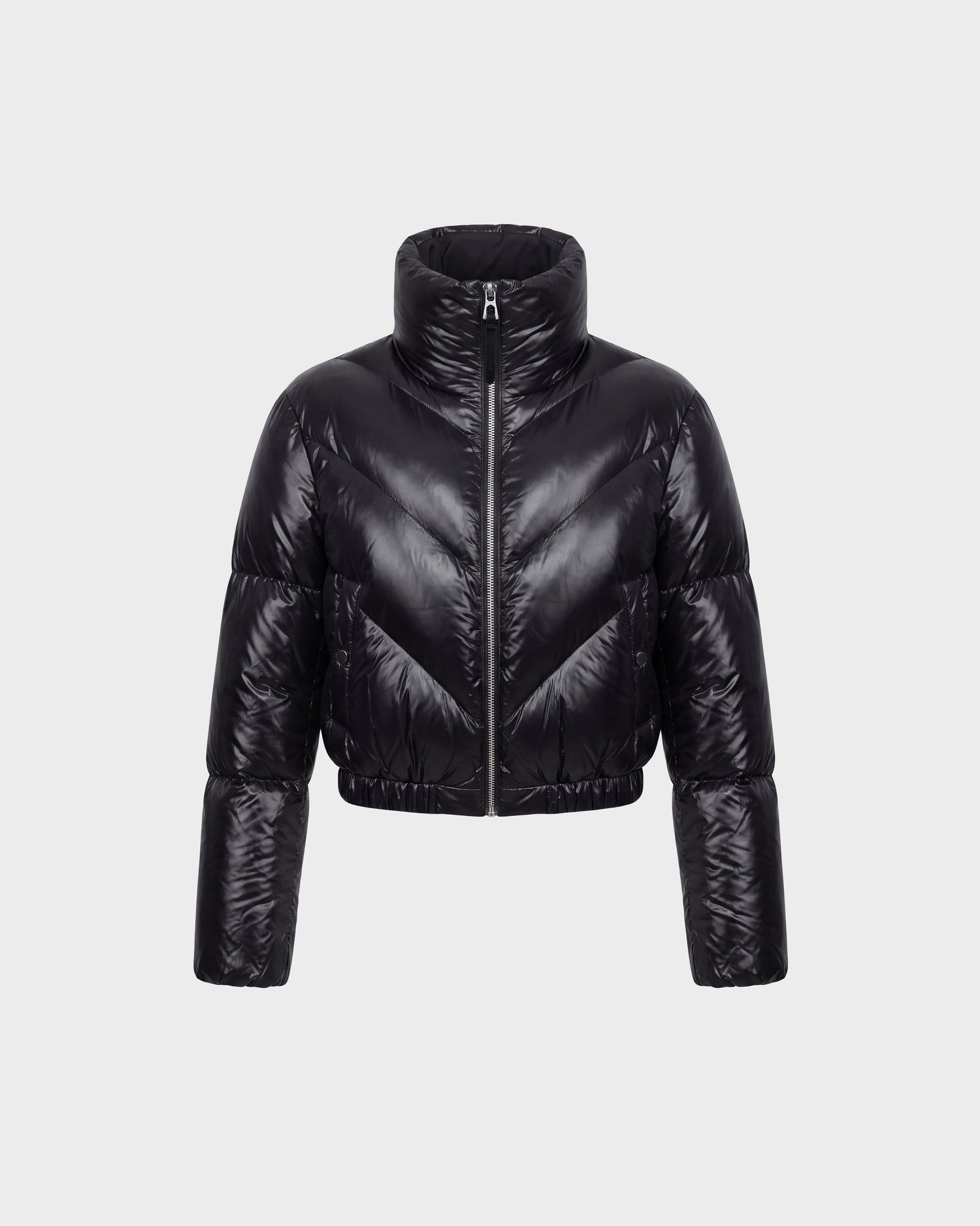 The Rudsak ANSLIE C - 8126713 Black women’s down puffer jacket features a shiny black, cropped silhouette with a high collar and full-length sleeves, displayed on a plain light grey background. Filled with RDS-certified down for exceptional warmth and comfort, this fashion-forward piece is designed with a front zipper closure and horizontal quilted sections.
