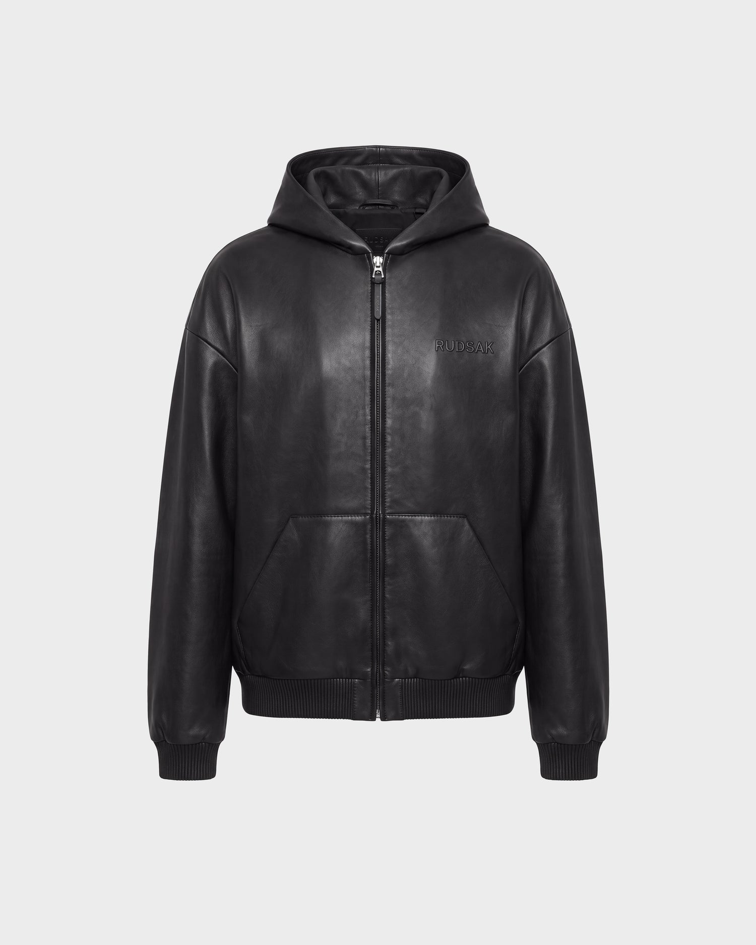 Rudsak ARCHIE - 6126500 Black leather hooded jacket featuring a front zipper, side pockets, ribbed cuffs and hem, and subtle embossed text on the left chest, displayed on a plain light gray background.